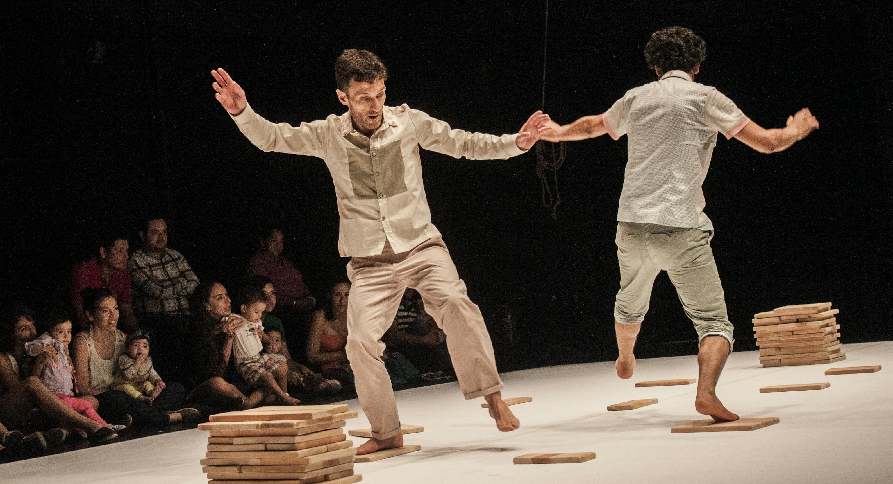 Two performers dancing on stage in front of an audience