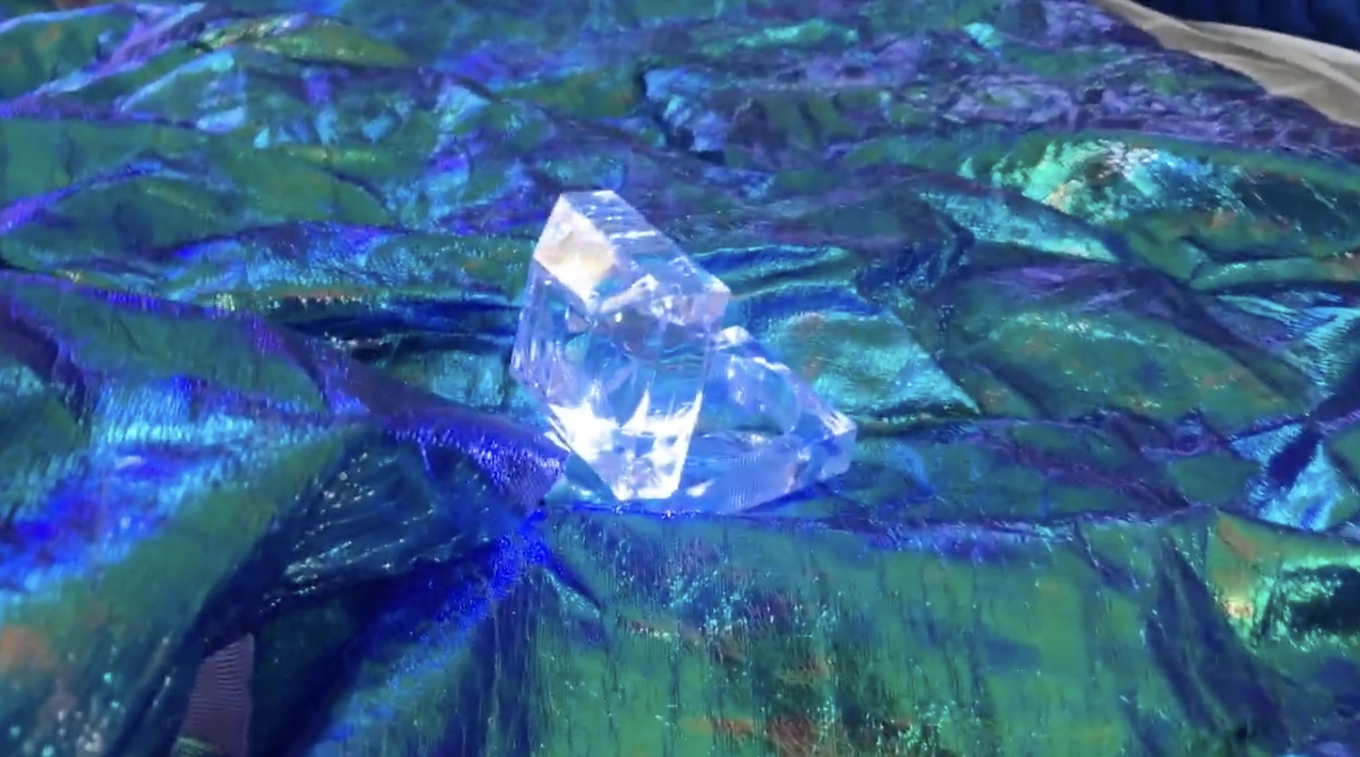 A light shines brightly surrounded by blue/green materials 