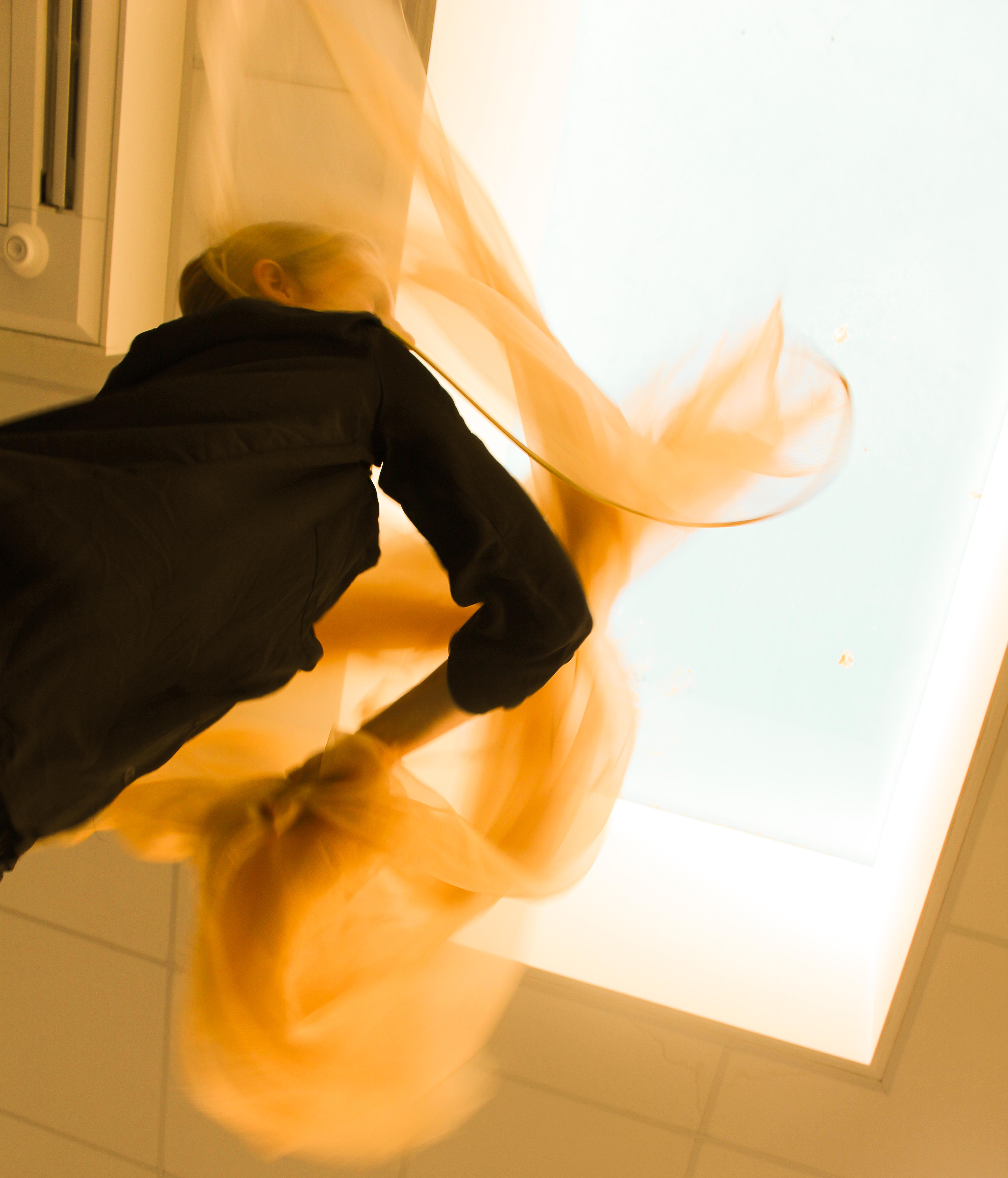 A performer wearing black is moving a piece of material around