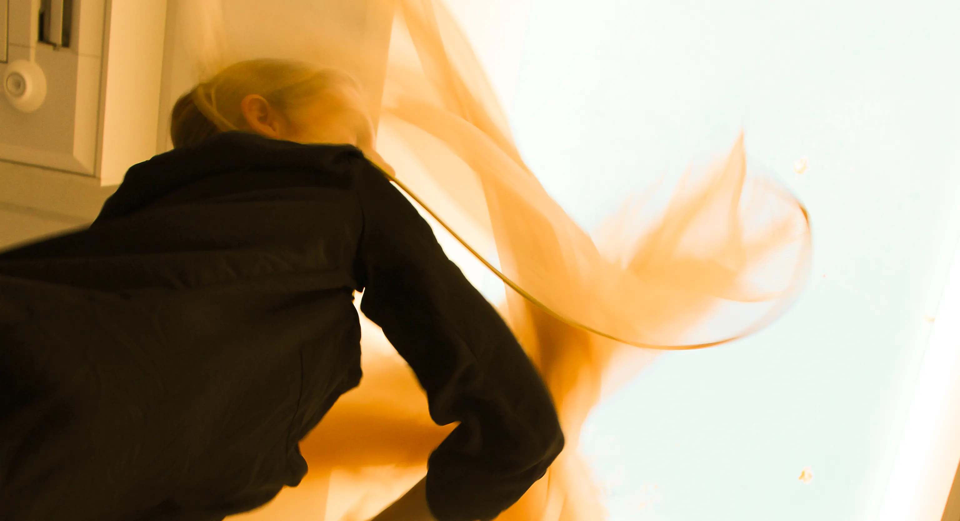 A performer wearing black is moving a piece of material around