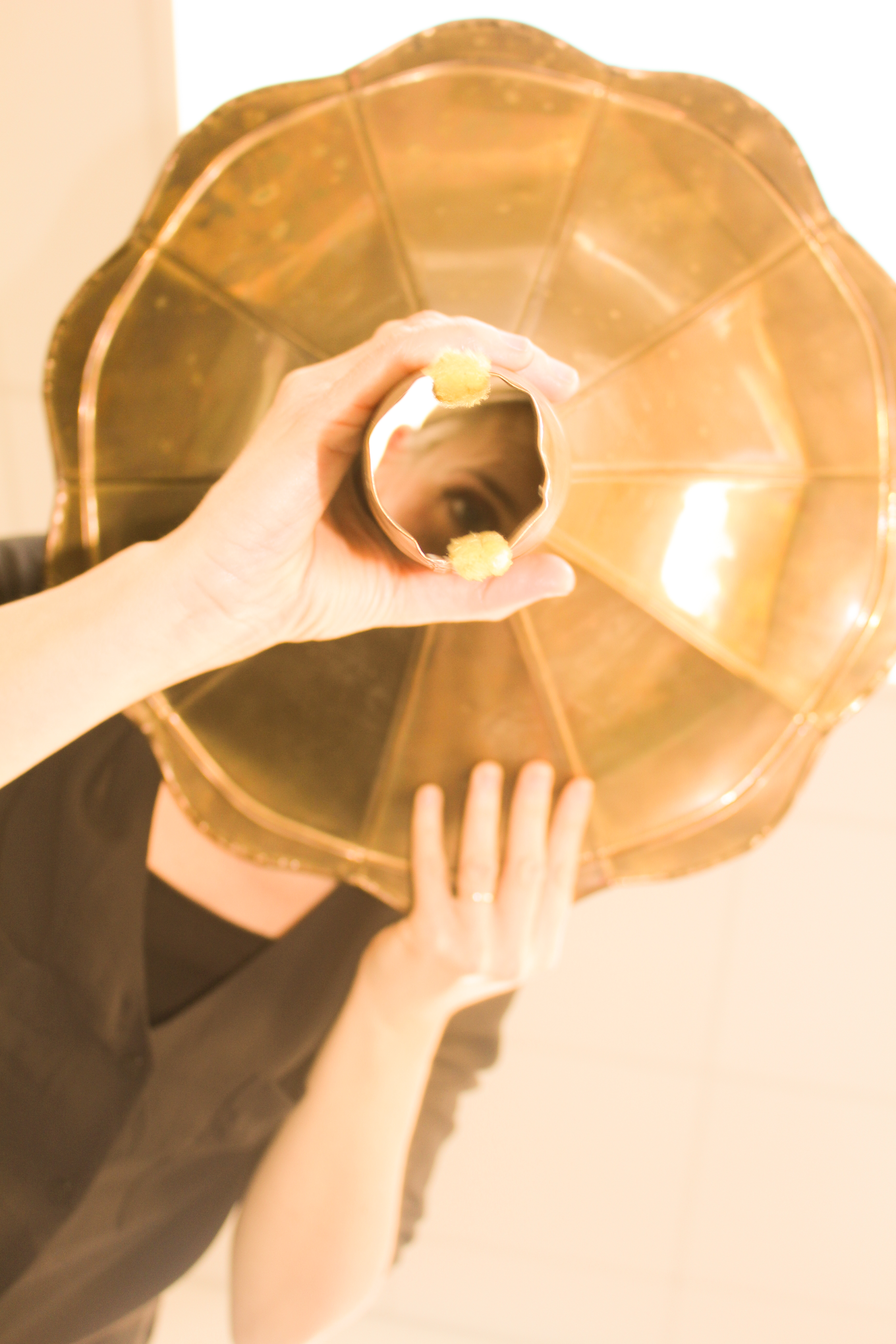 A performer is looking through a hole from an instrument 