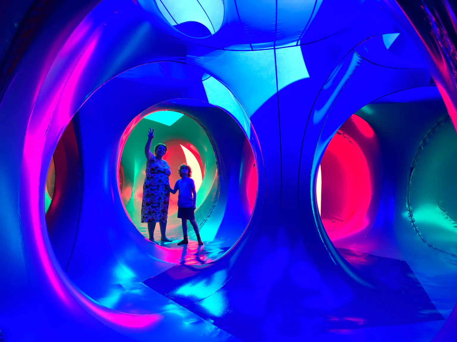 An adult and young child standing inside an inflatable