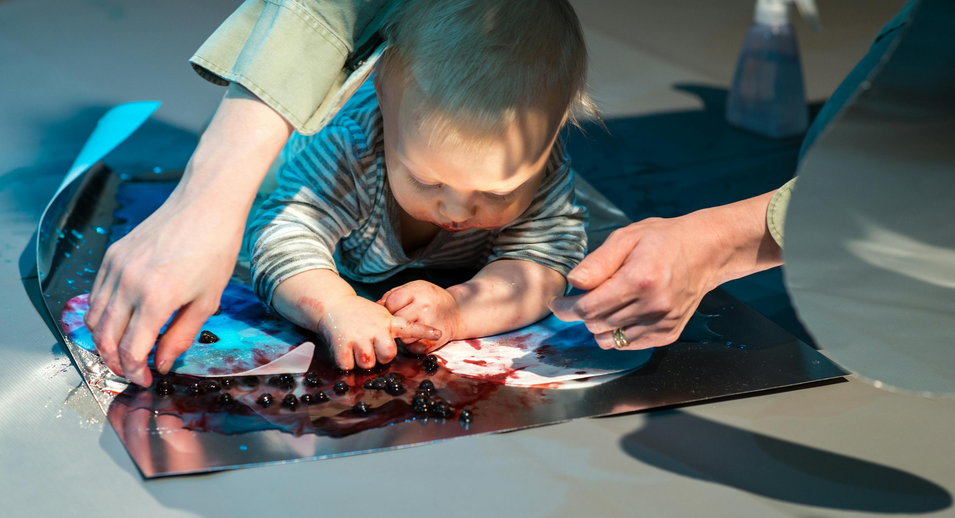 Colour Workshops: a baby lying on their front and engaging with colours