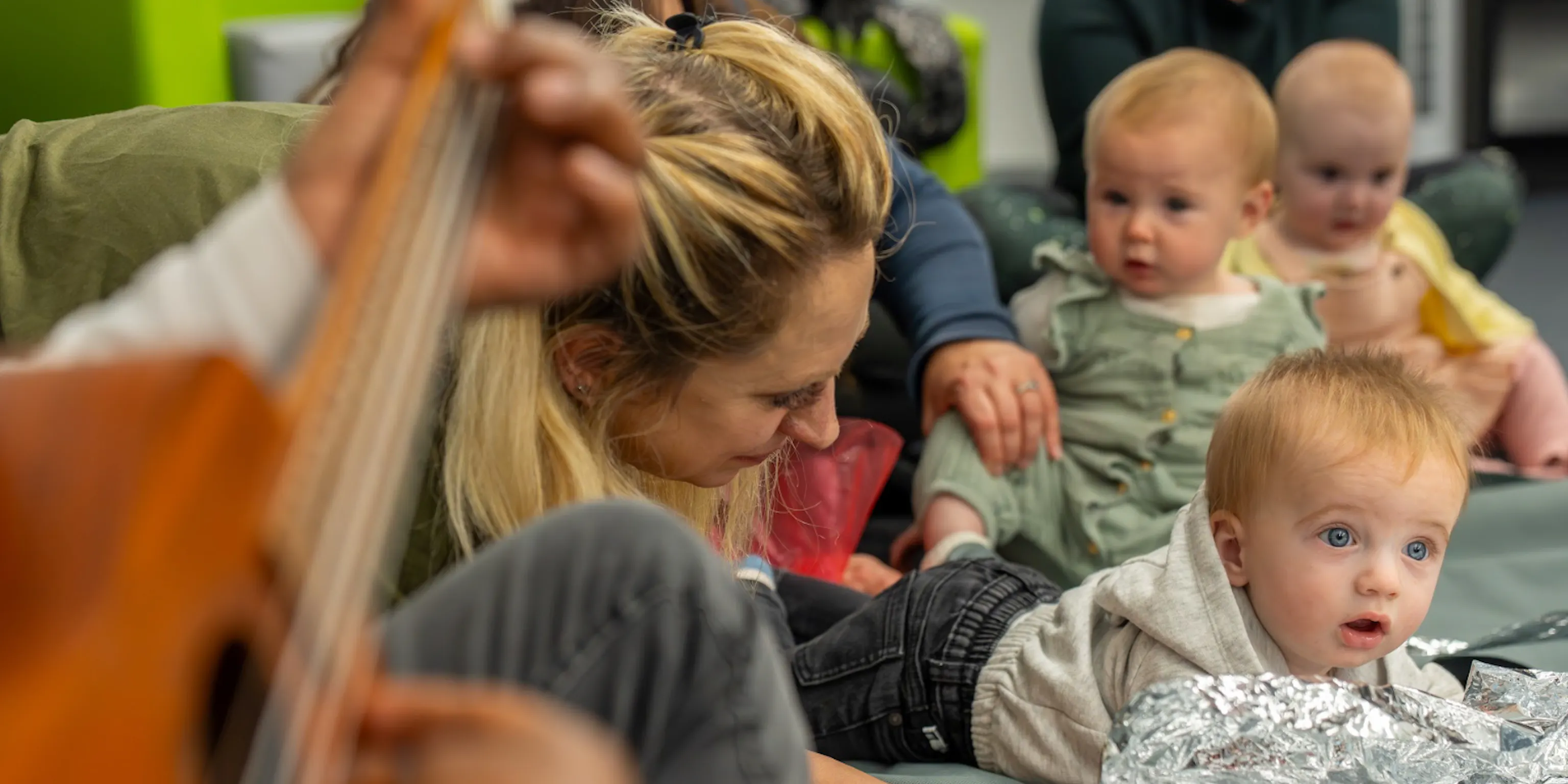 A group of children and parents/carers in a Playground session interacting with each other and the artists