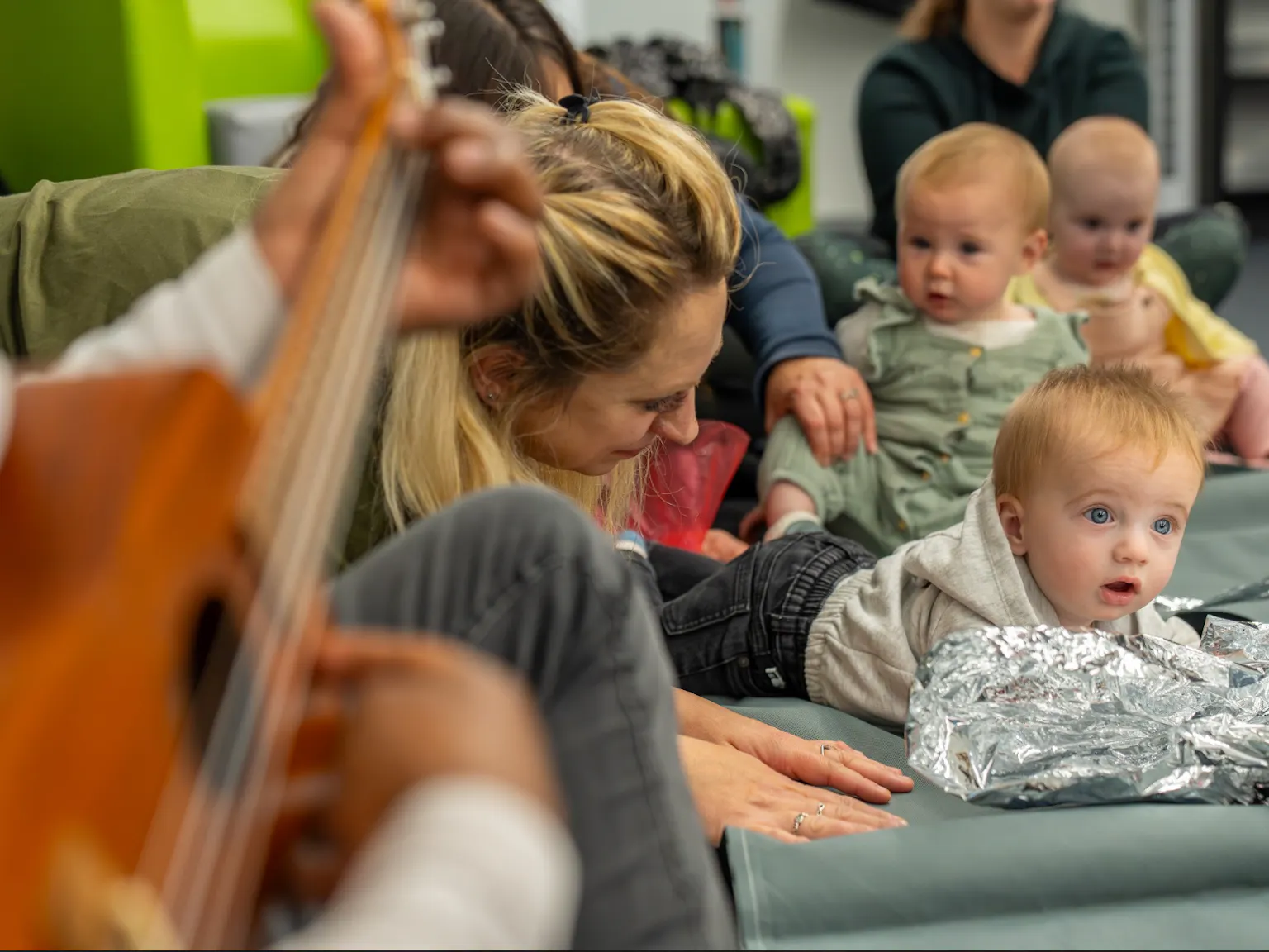 A group of children and parents/carers in a Playground session interacting with each other and the artists