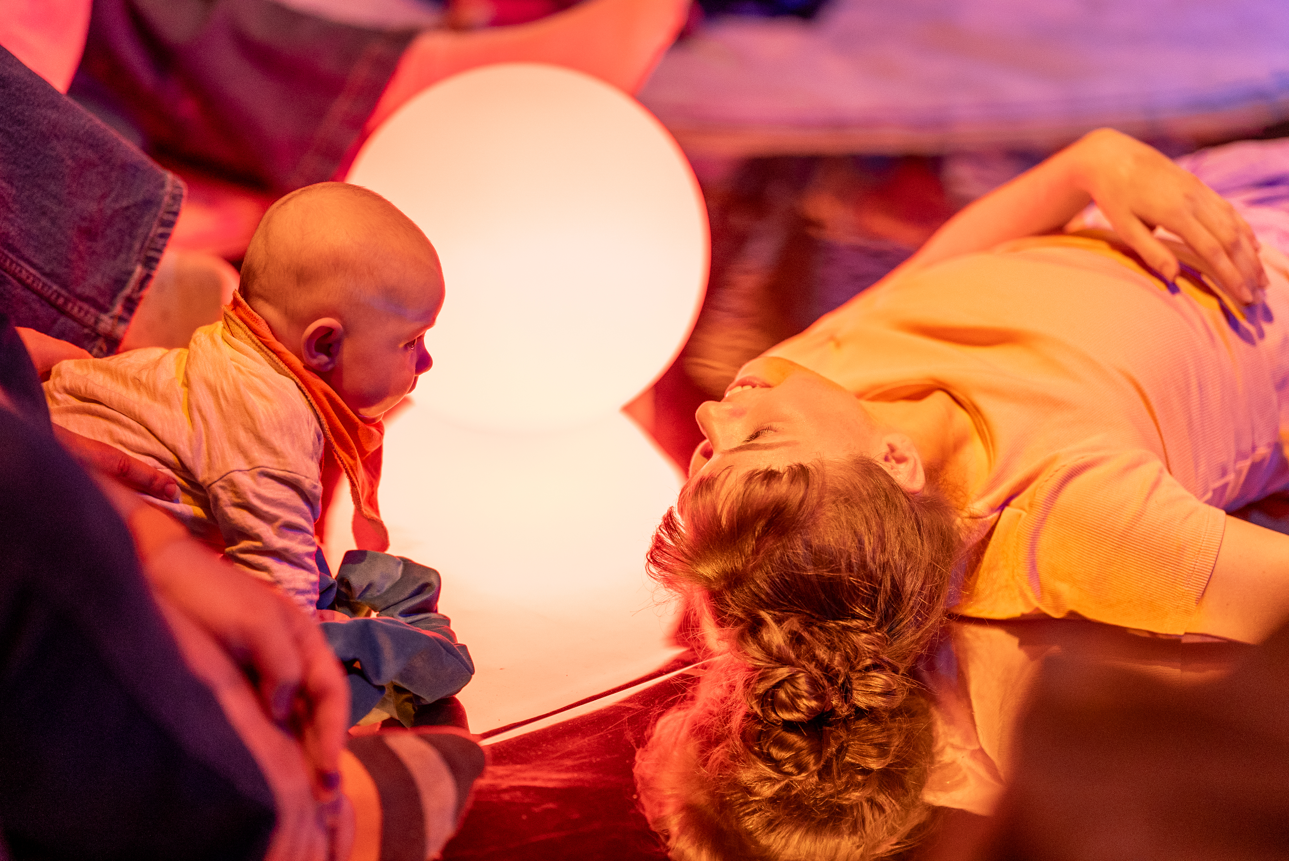 A performer and baby look into each others eyes