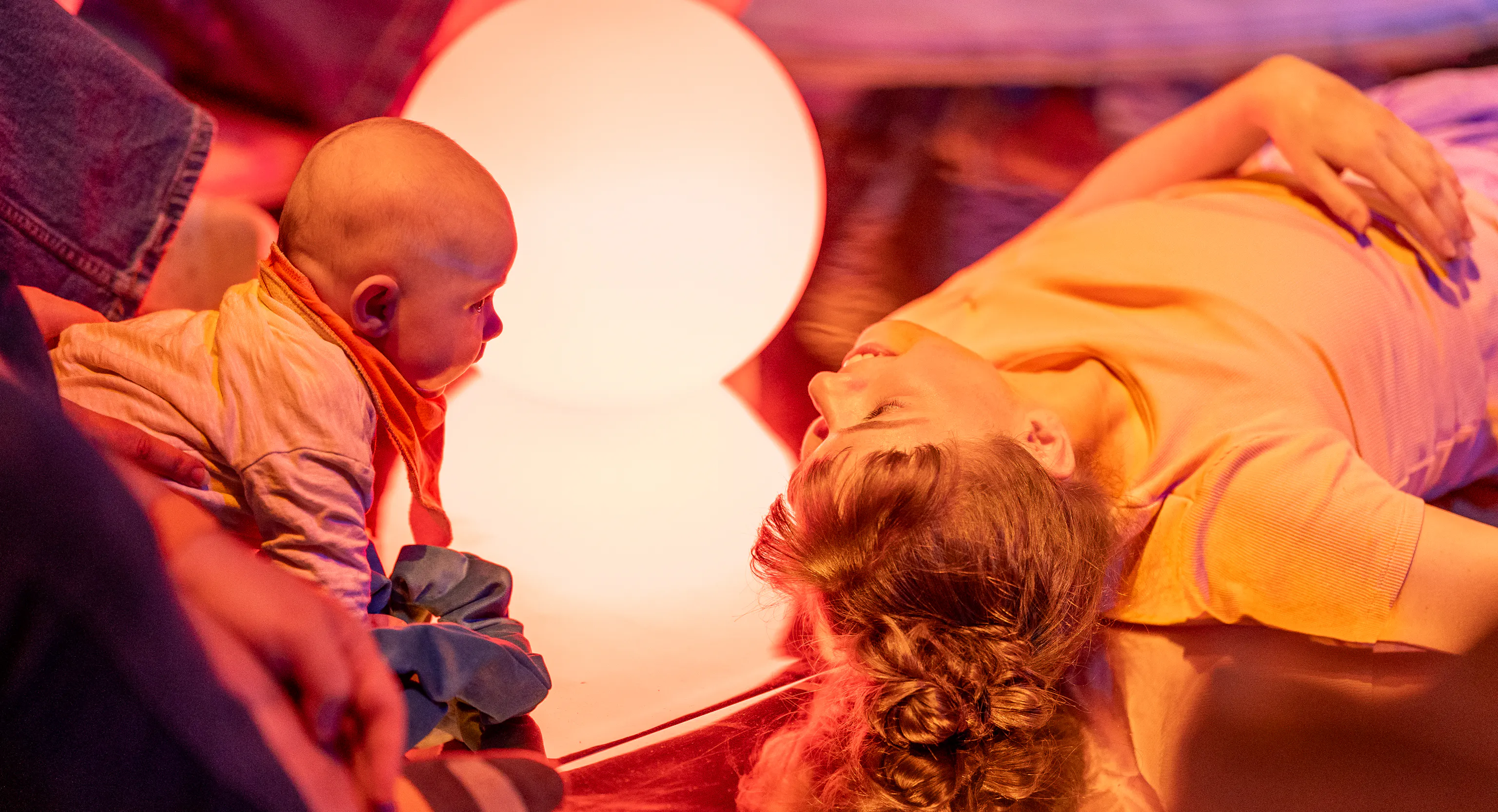 A performer and baby look into each others eyes