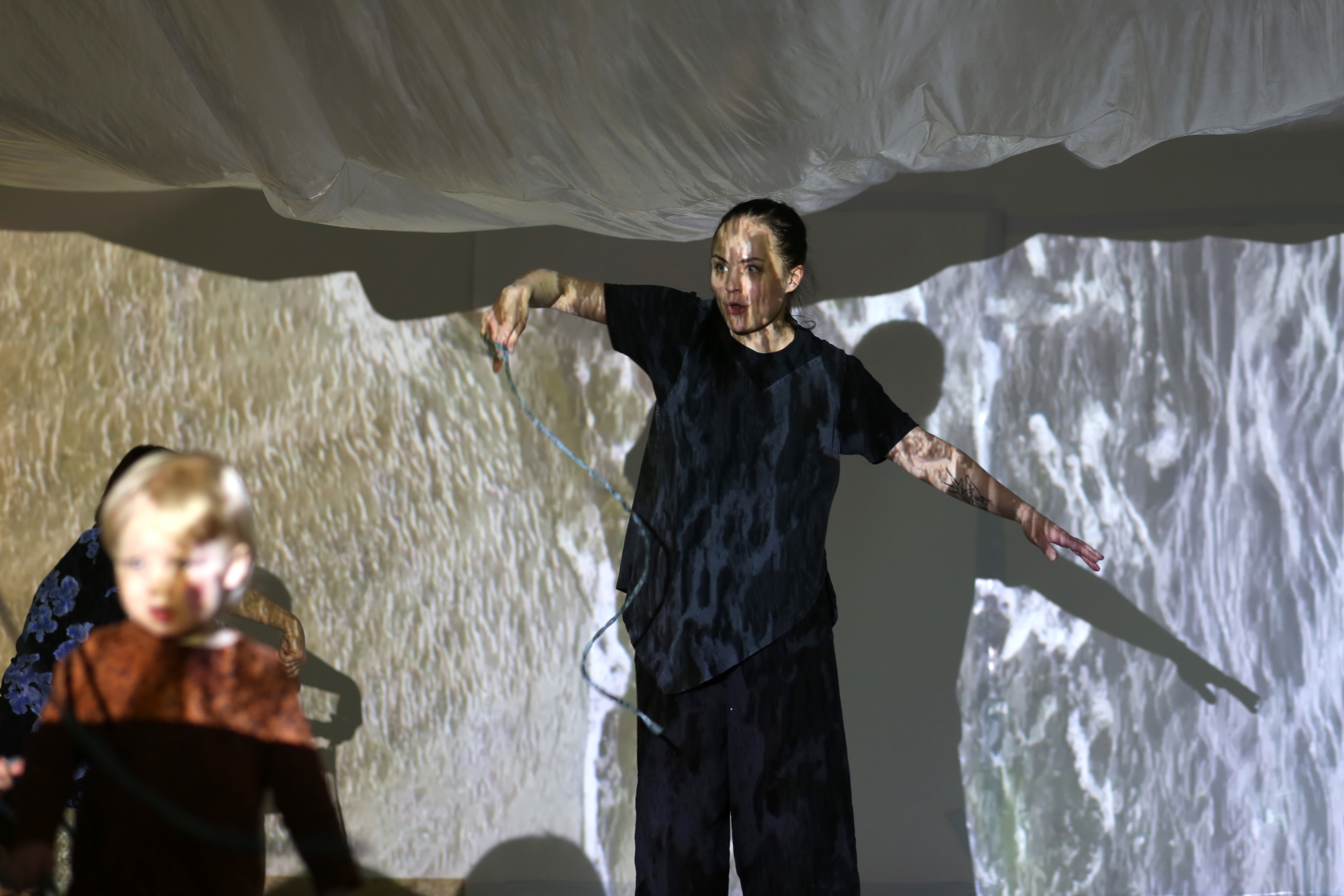 An artist stands in front of projections in a room
