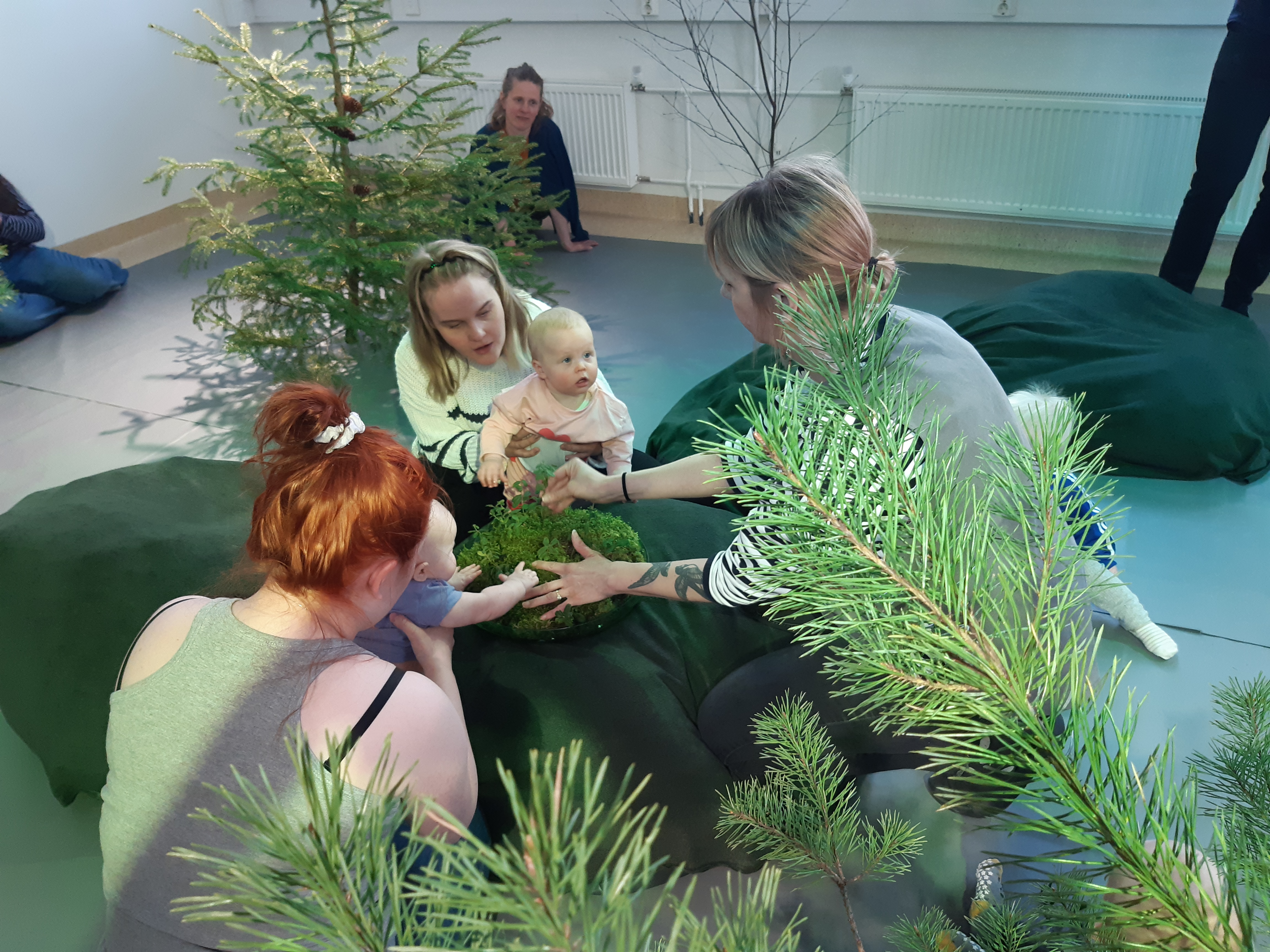 Babies and parents/carers engaging with  plant material in a workshop 
