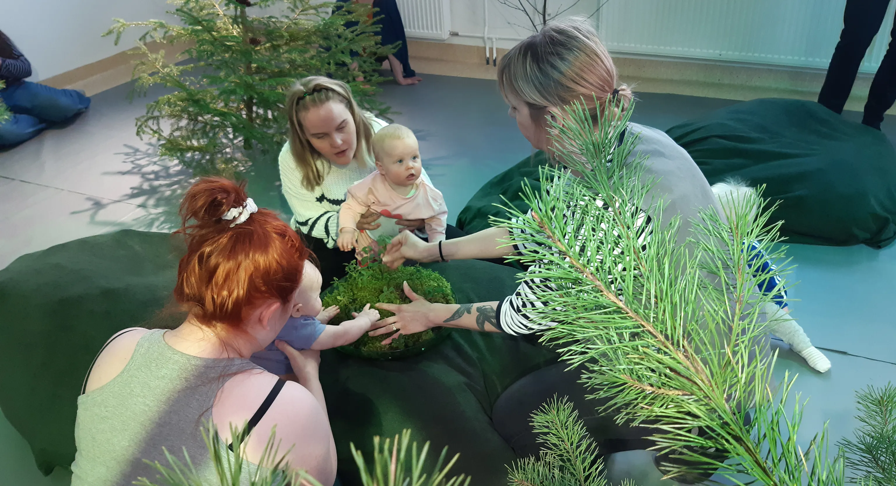 Babies and parents/carers engaging with plant material in a workshop