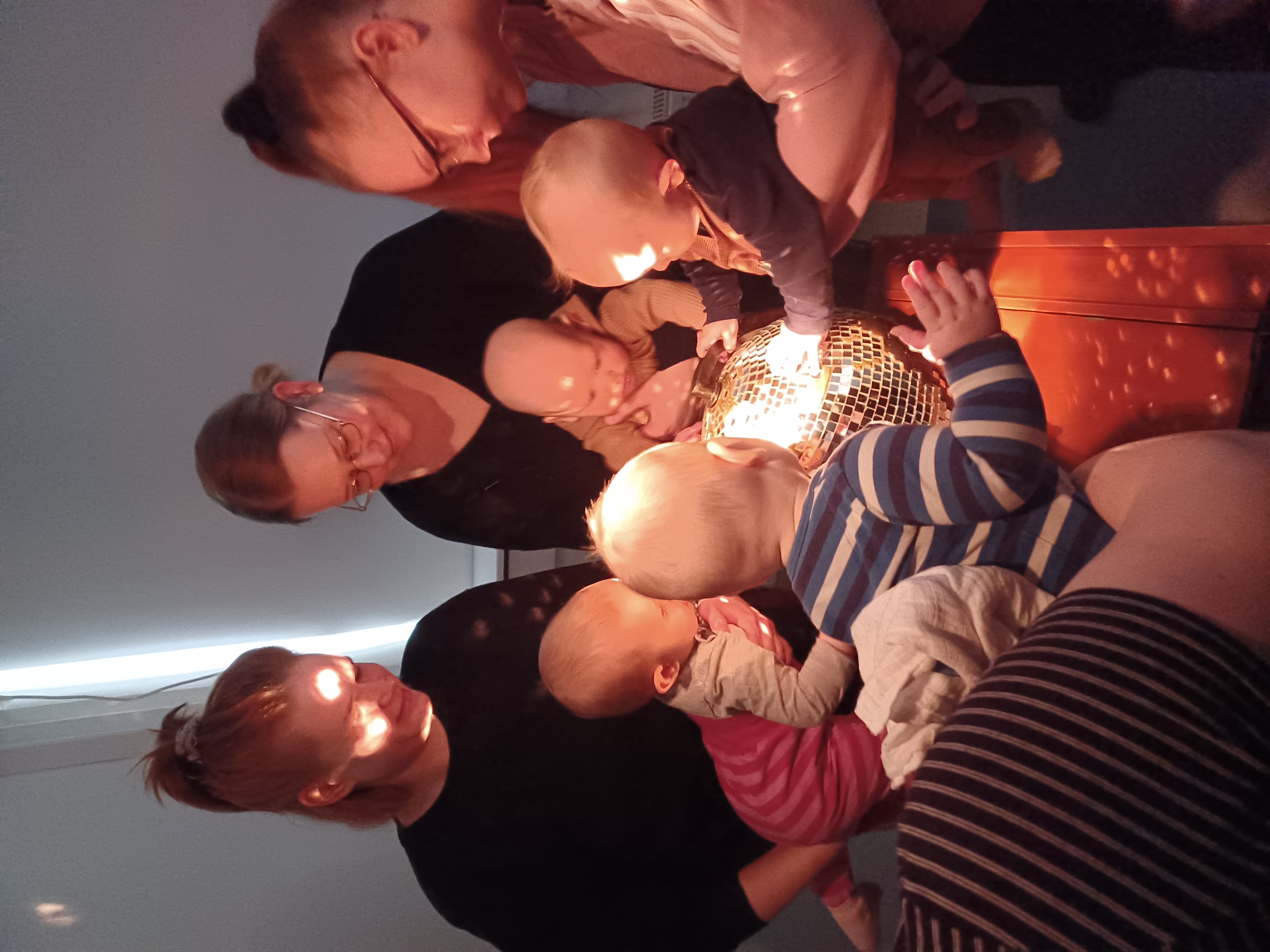 A group of parents and babies engaging with light 