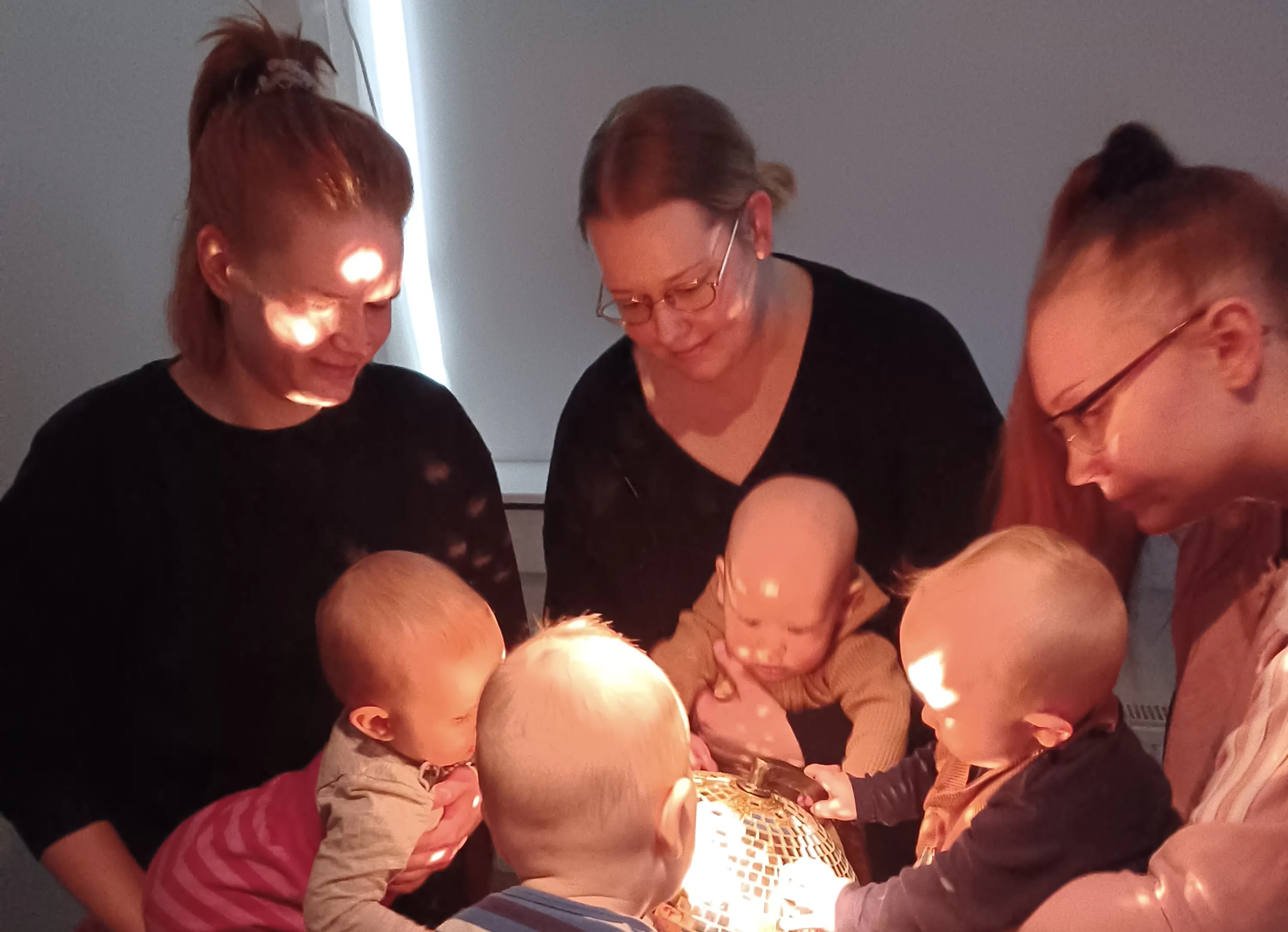A group of parents and babies engaging with light