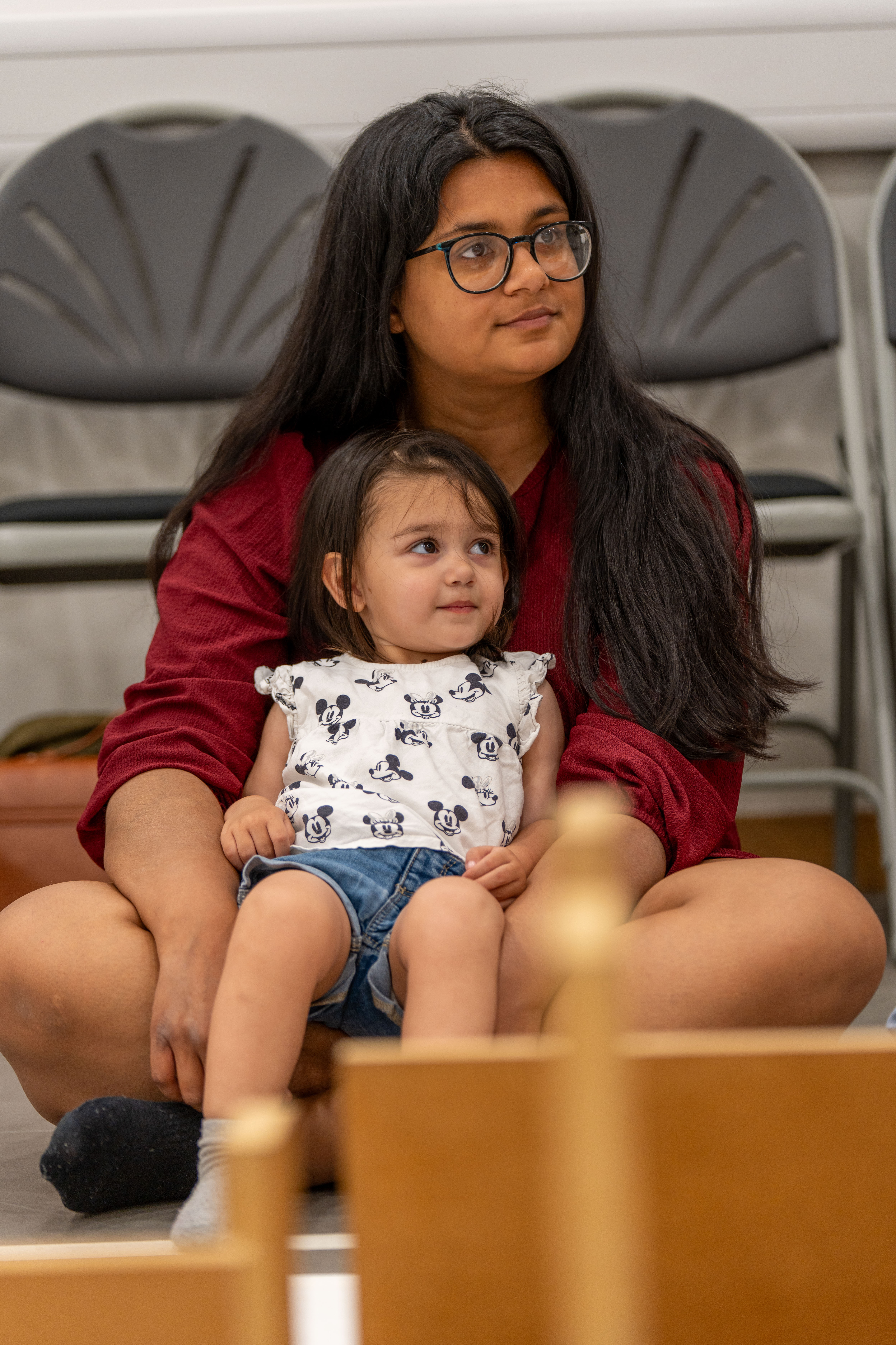 A young child sitting with their mother/carer