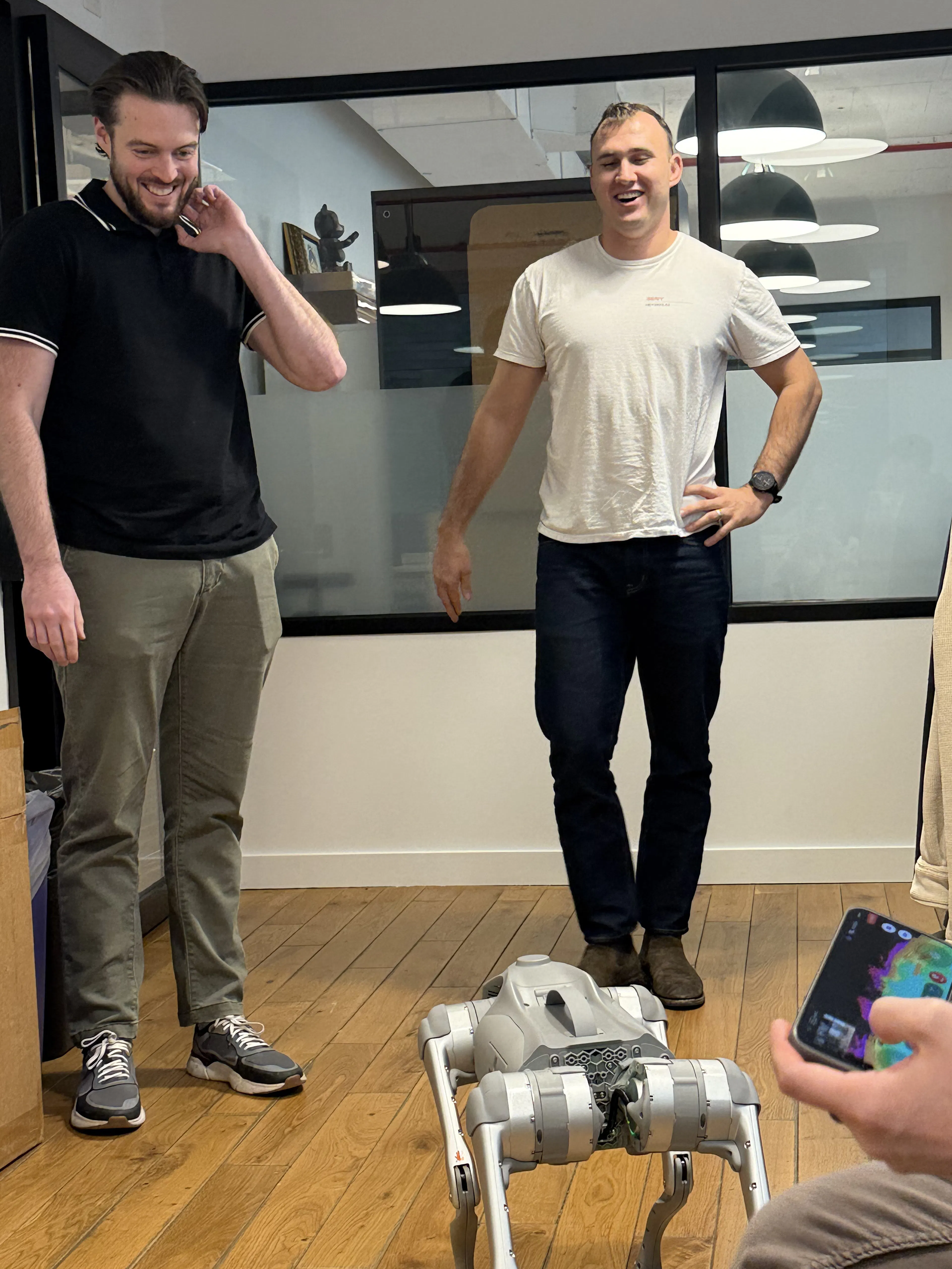 two co-workers looking at robot dog