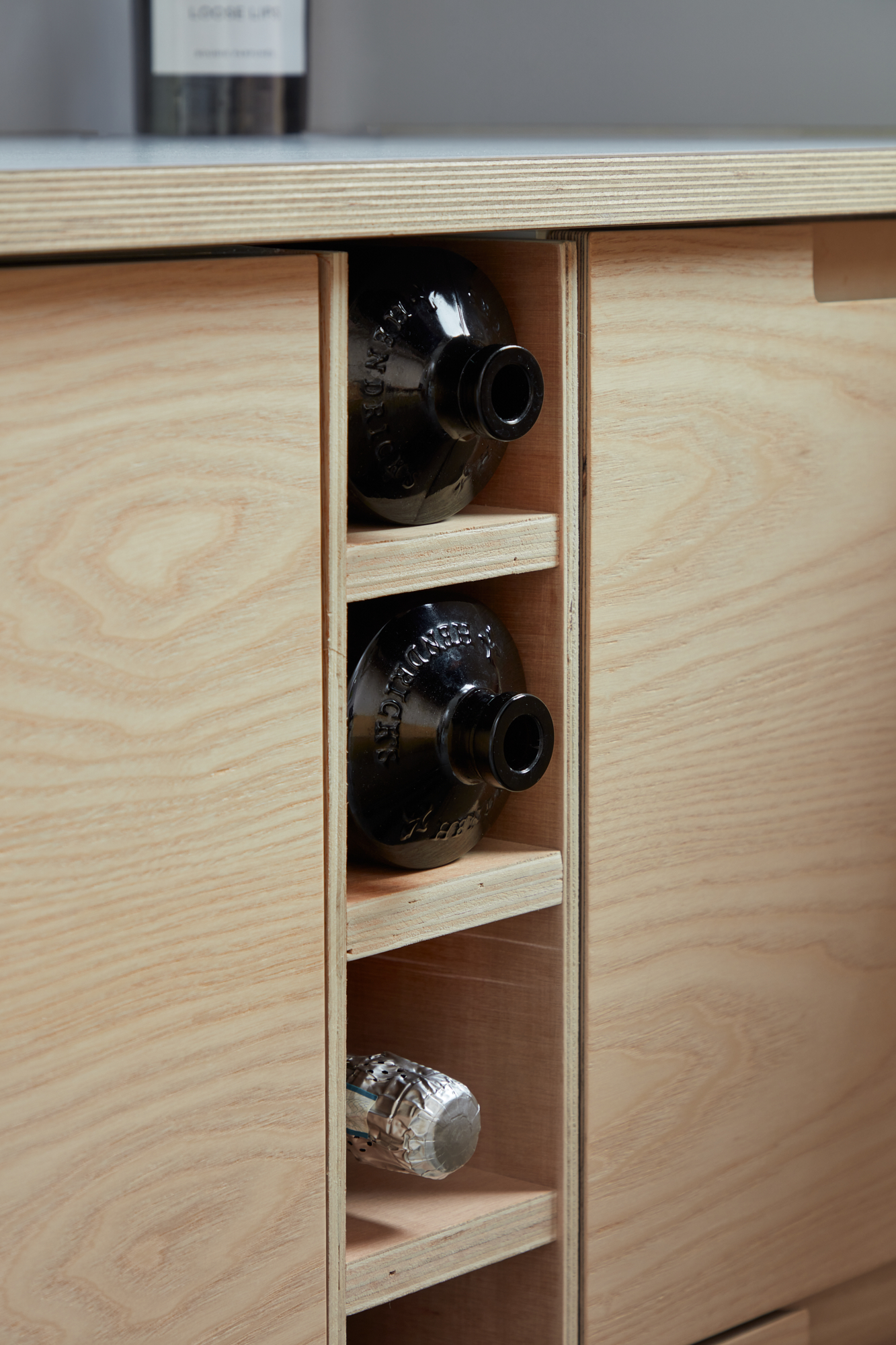 Plykea ash plywood fronts with semi-recessed handles and a Formica Glacier worktop