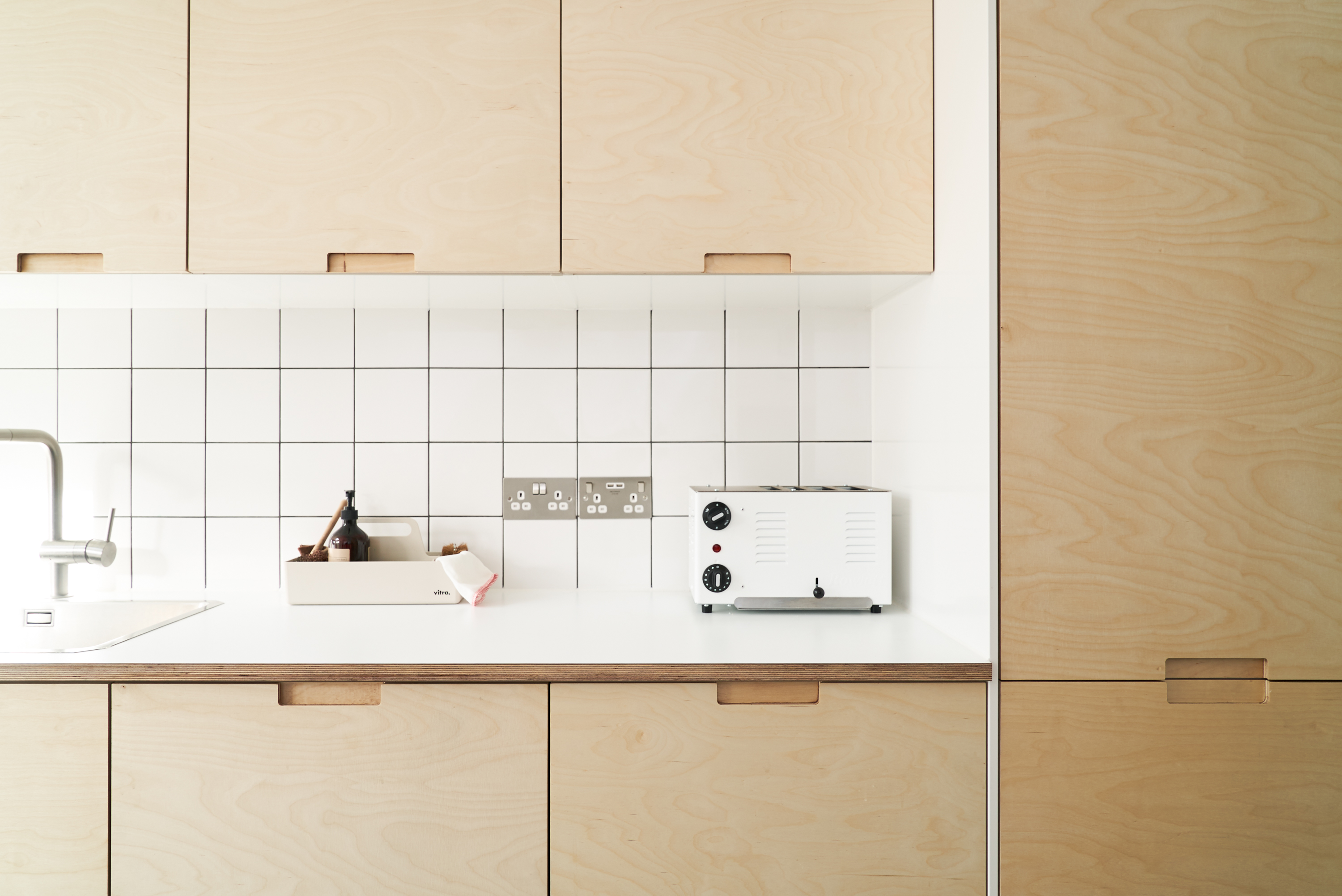 Birch plywood fronts, Formica countertops and semi-recessed grab handles