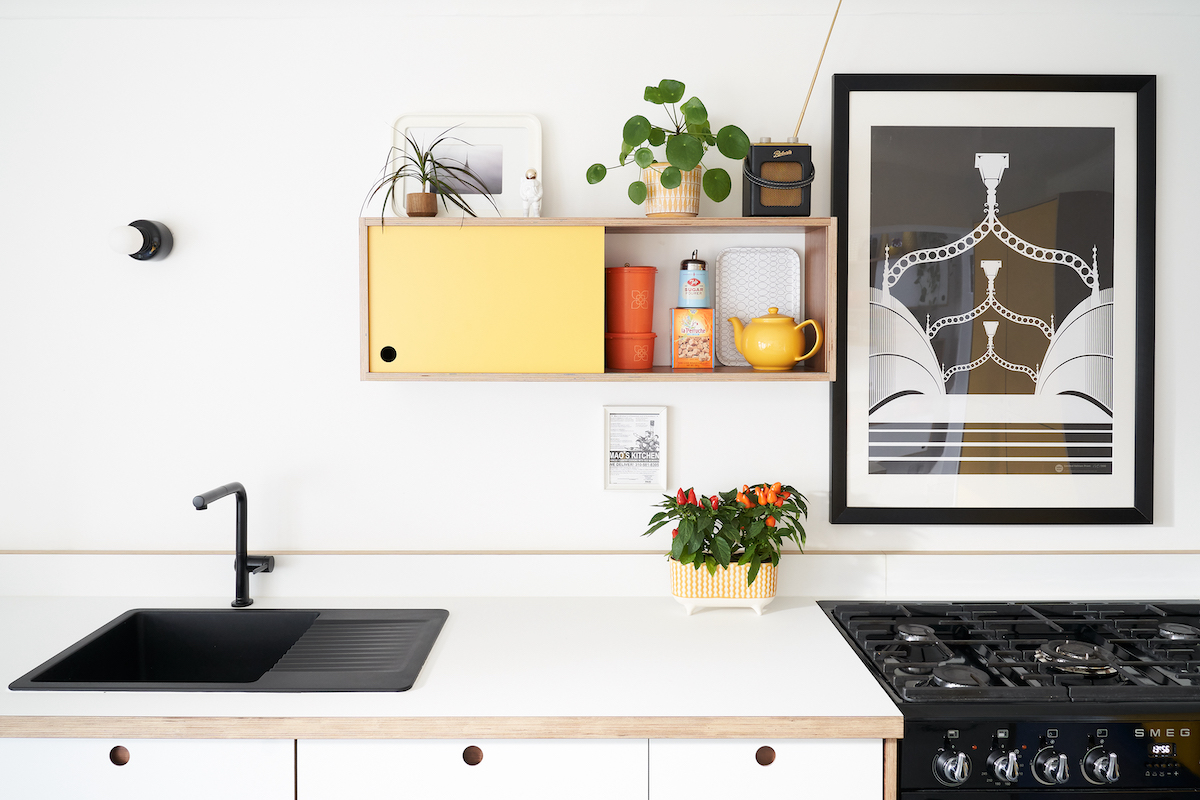 Plykea white Fenix fronts and worktop with an Ürtil unit in walnut and Formica Spectrum Yellow