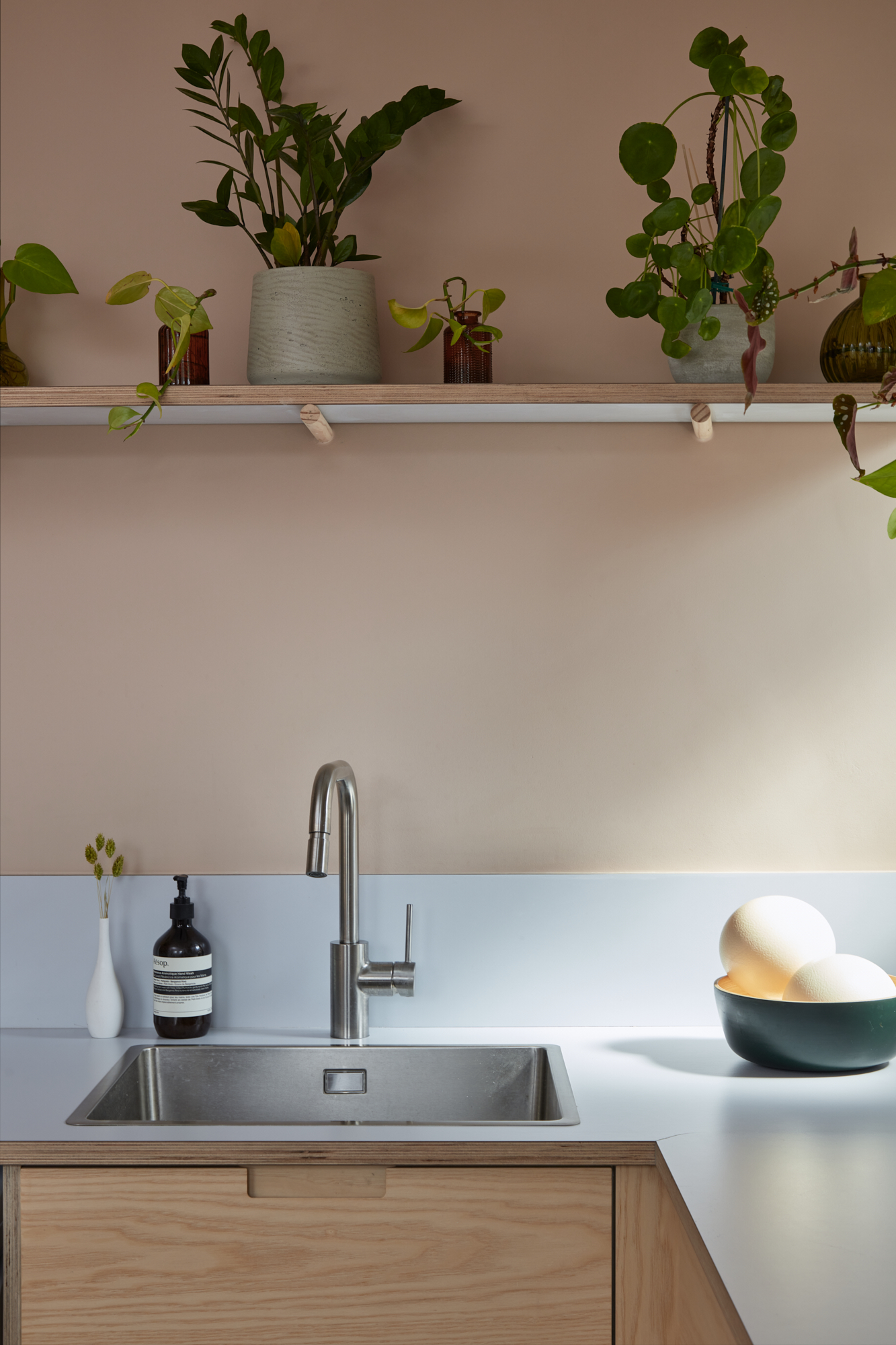 Plykea ash plywood fronts with semi-recessed handles and a Formica Glacier worktop and upstand