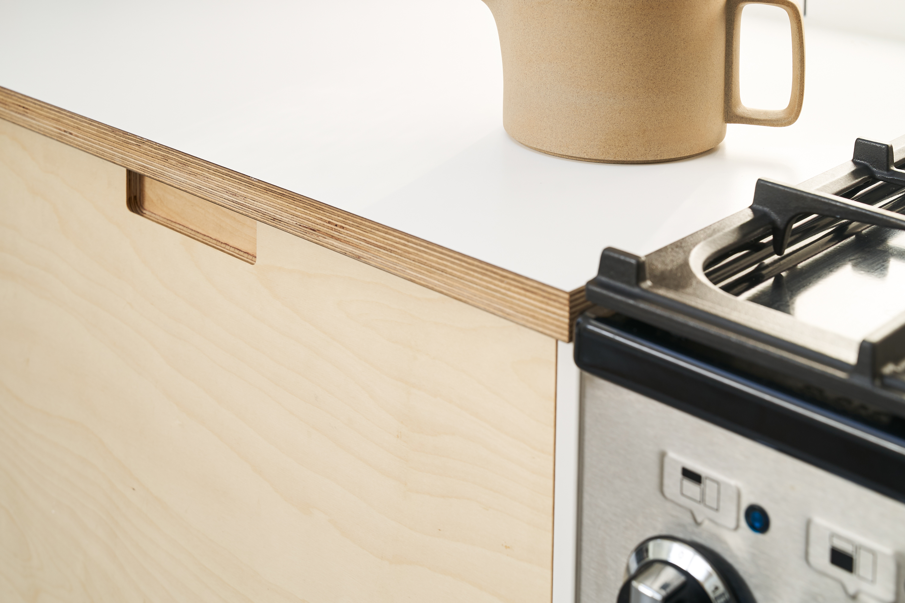 Birch plywood fronts, Formica countertops and semi-recessed grab handles