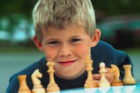 An image og Magnus Carlsen as a child in front of a chess board