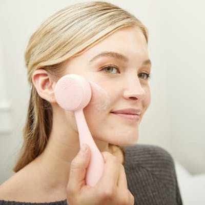 Woman massaging face with PMD Clean