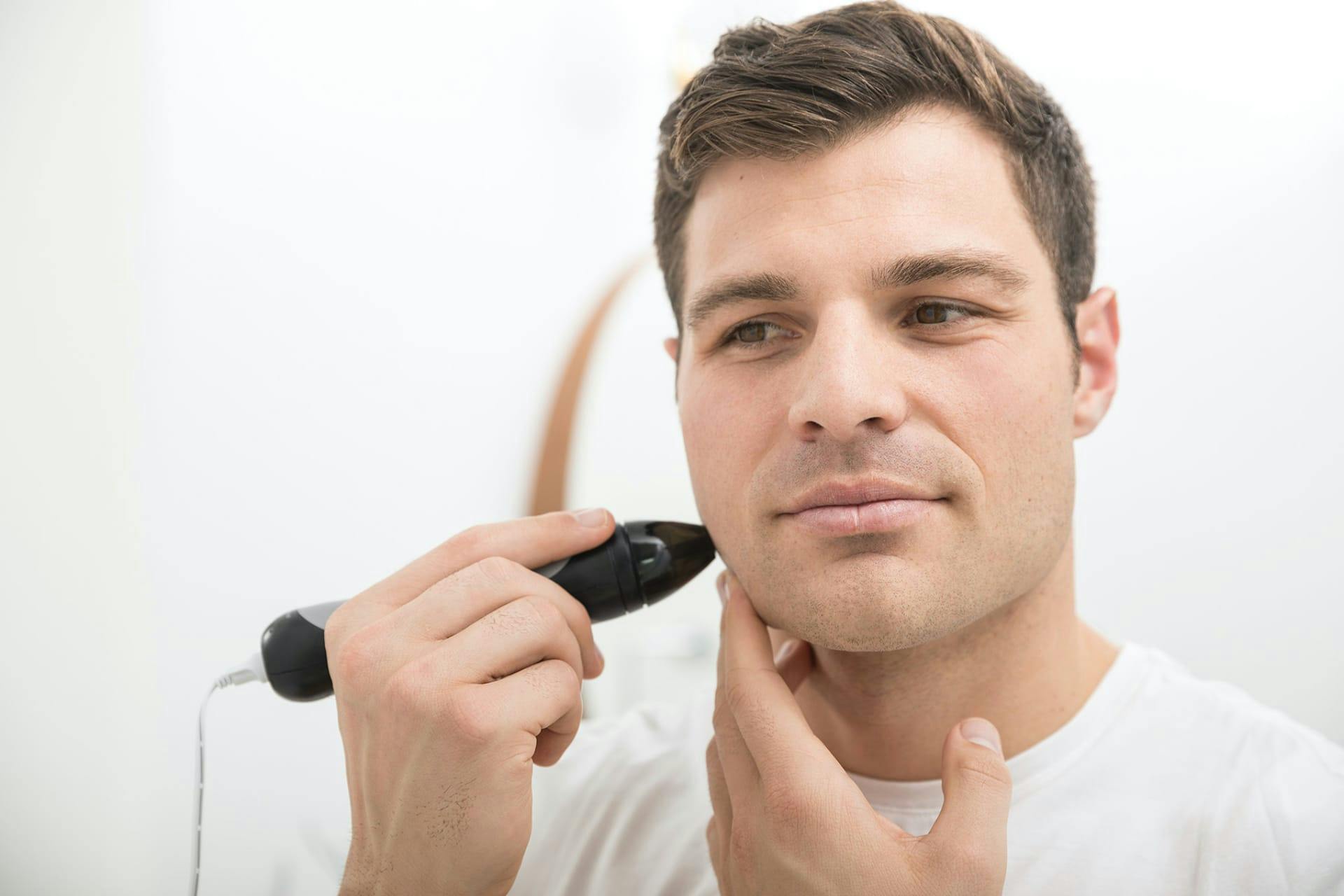 Man using Personal Microderm Man to treat face. 