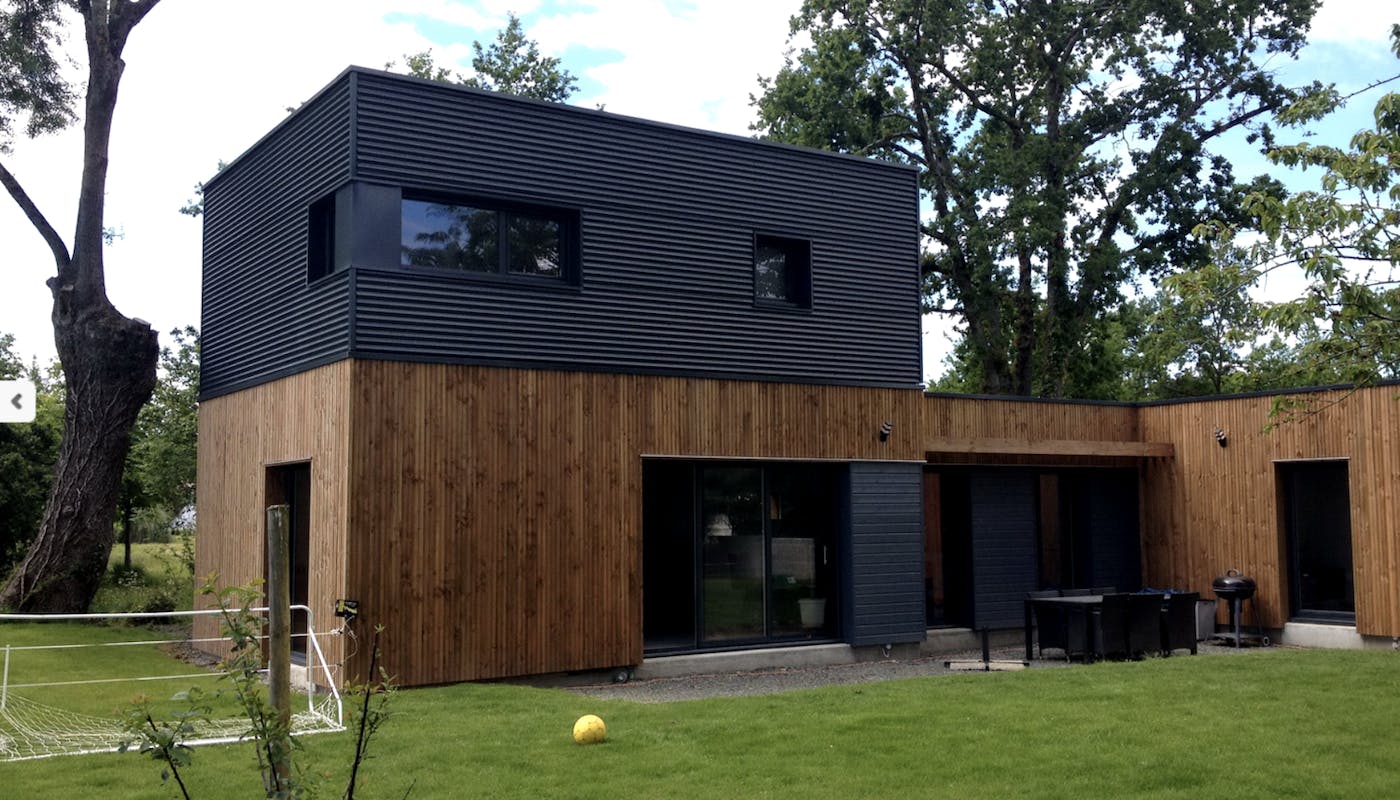 surélévation en container noir sur une maison moderne en bardage bois
