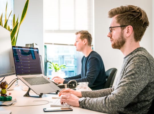 Two men working on computers.