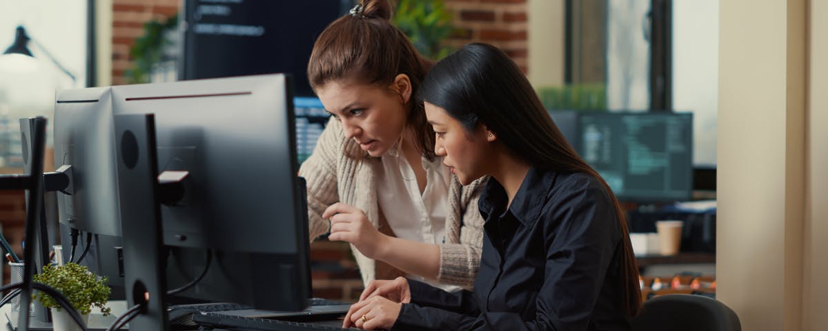 Two women working in the office in front of the pc