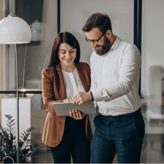 Two people smiling seeing something on the tablet