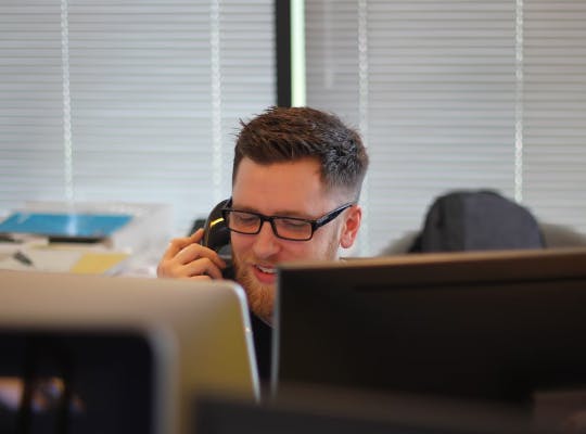 A man talking on the phone in the office