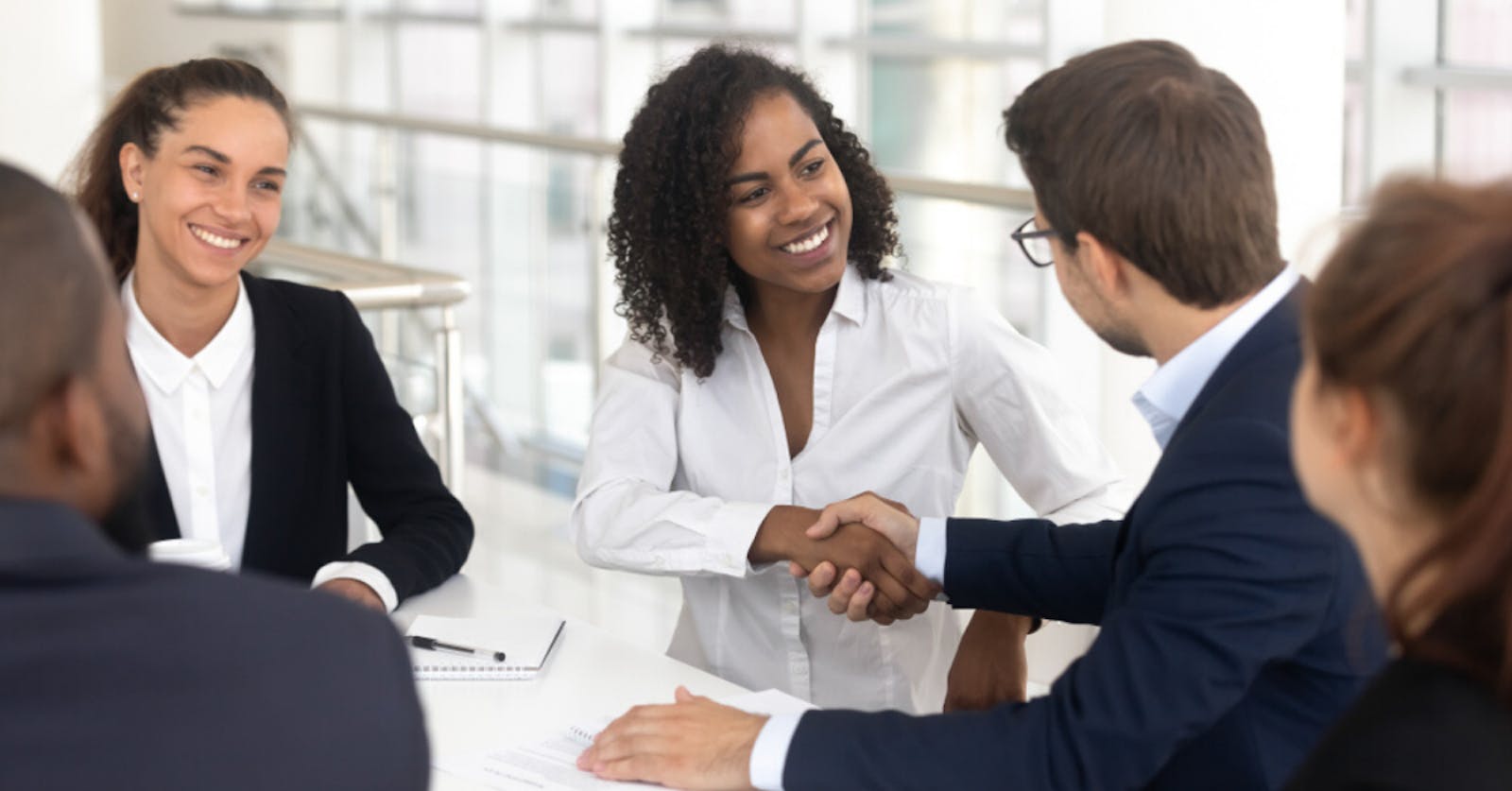 Team of mobile and app developers shaking hands