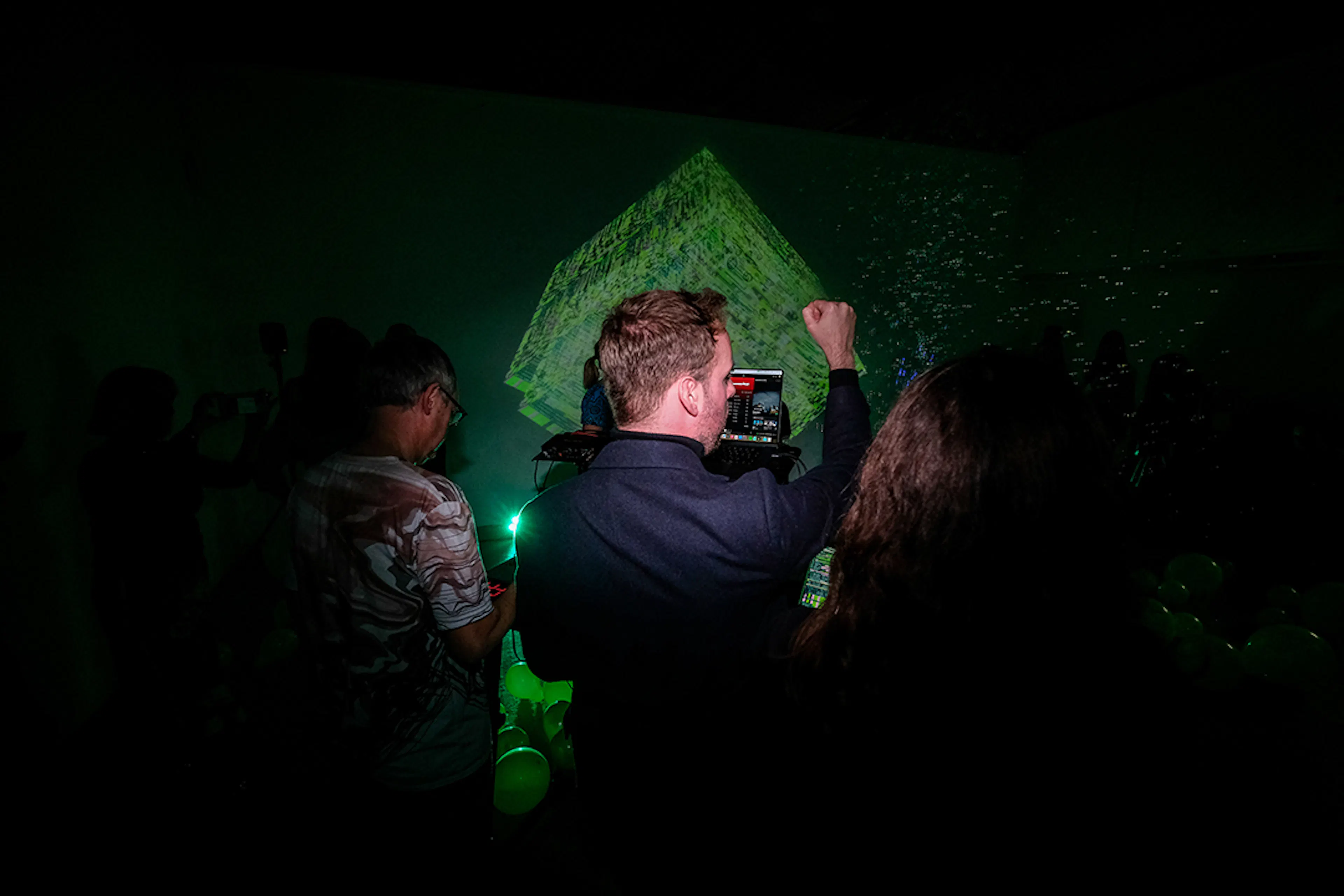 Nigel Fryatt live coding a green cube with his fist in the air. 