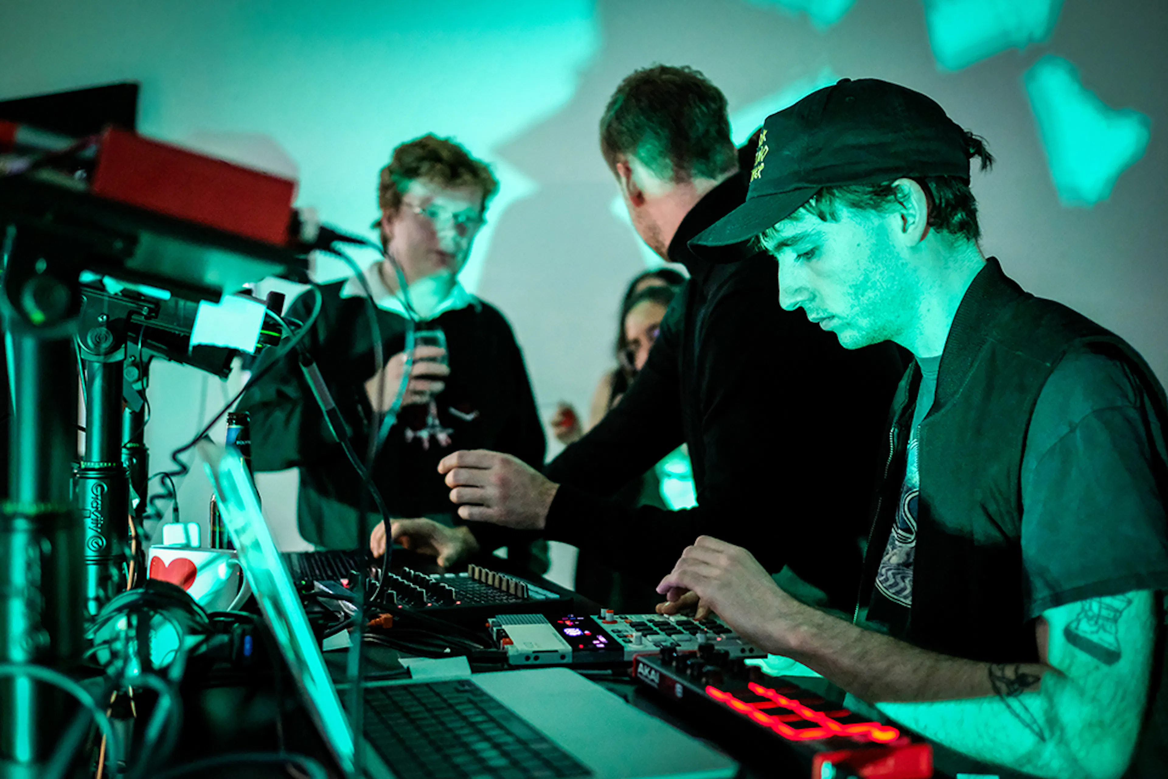 Felix Colbert making techno music realtime with audience members in the background. 