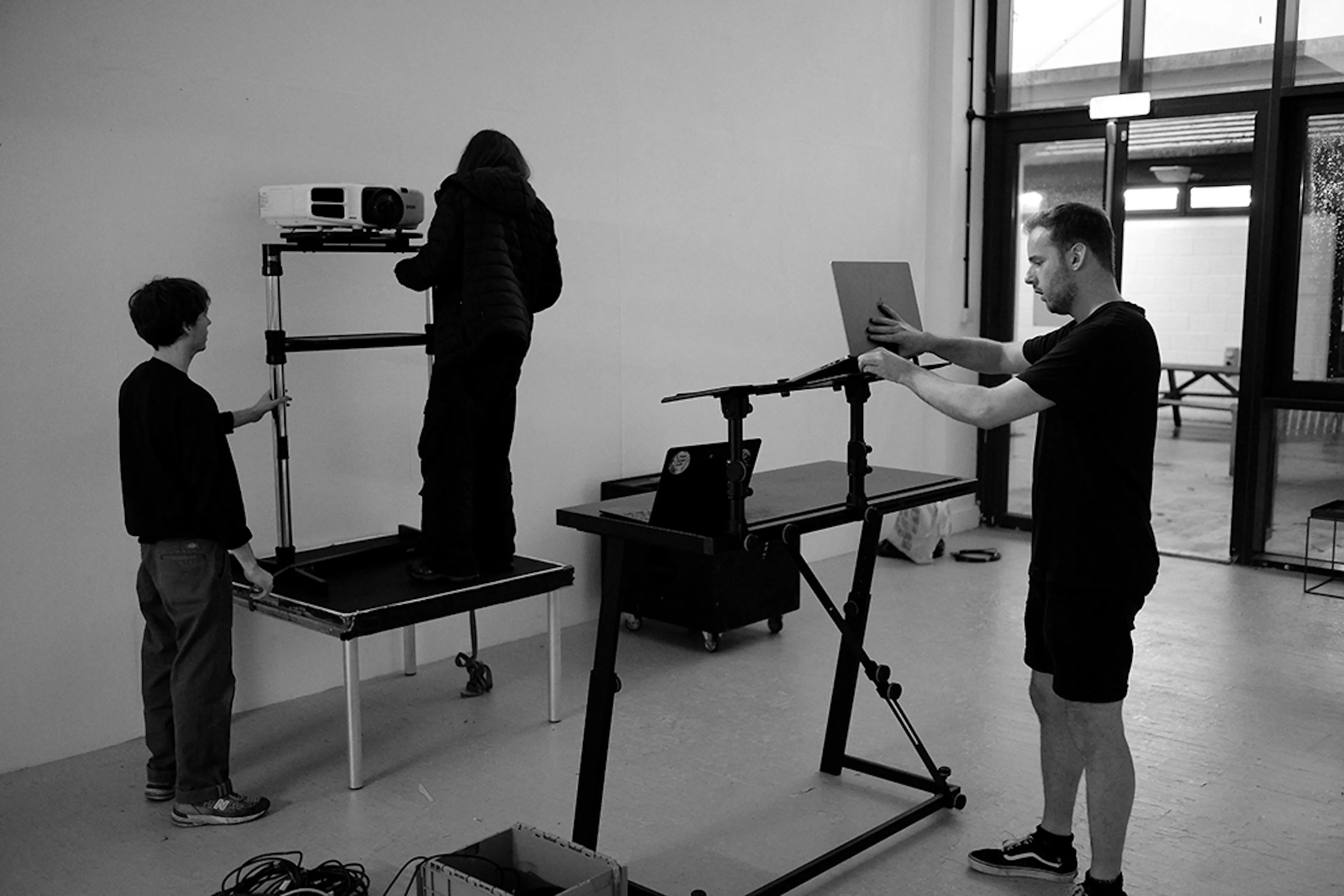 Felix Colbert, Clare Frances and Nigel Fryatt during setup. Black and white. 