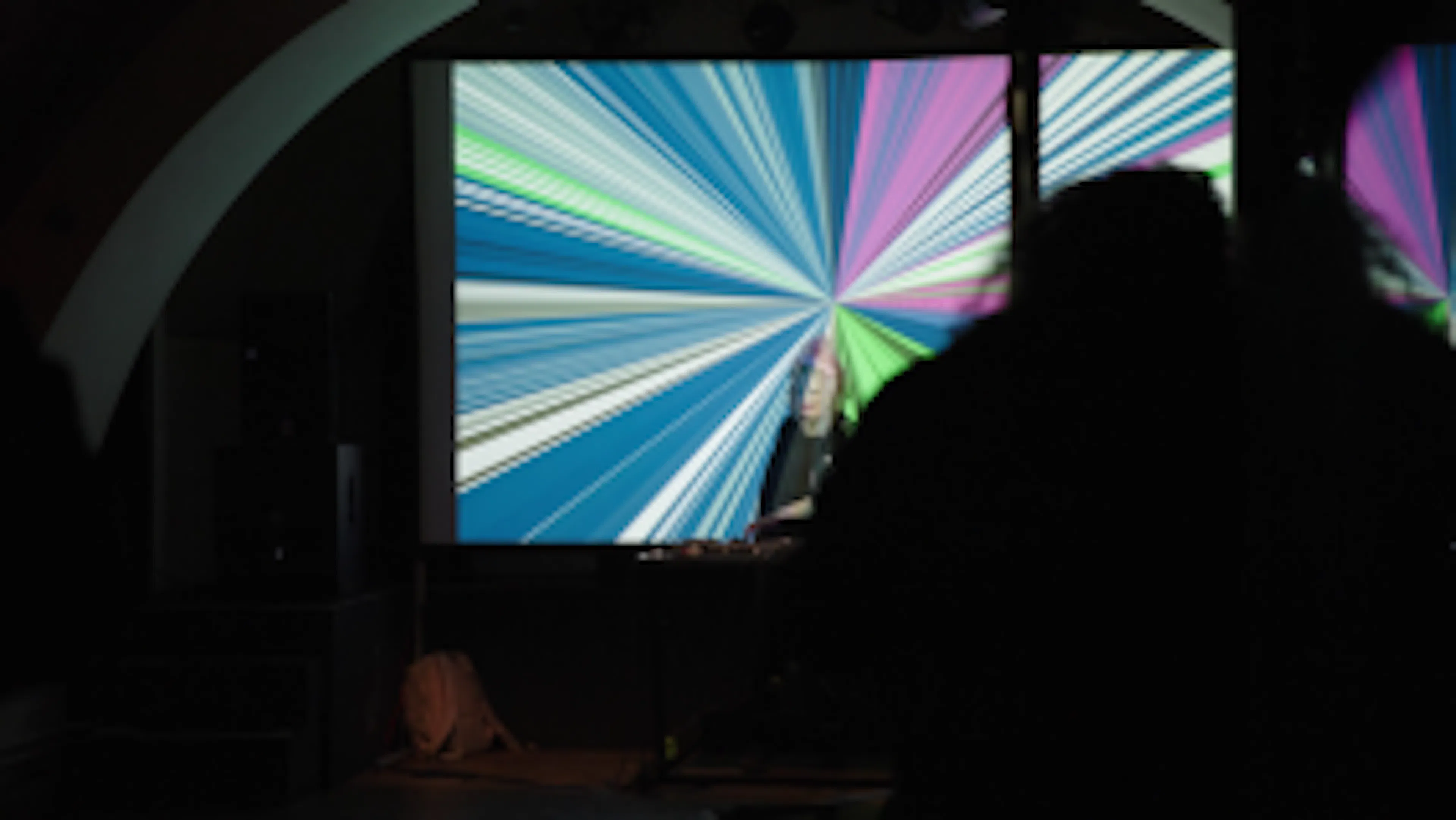 Remy Melee dj'ing in front of large projected visuals.