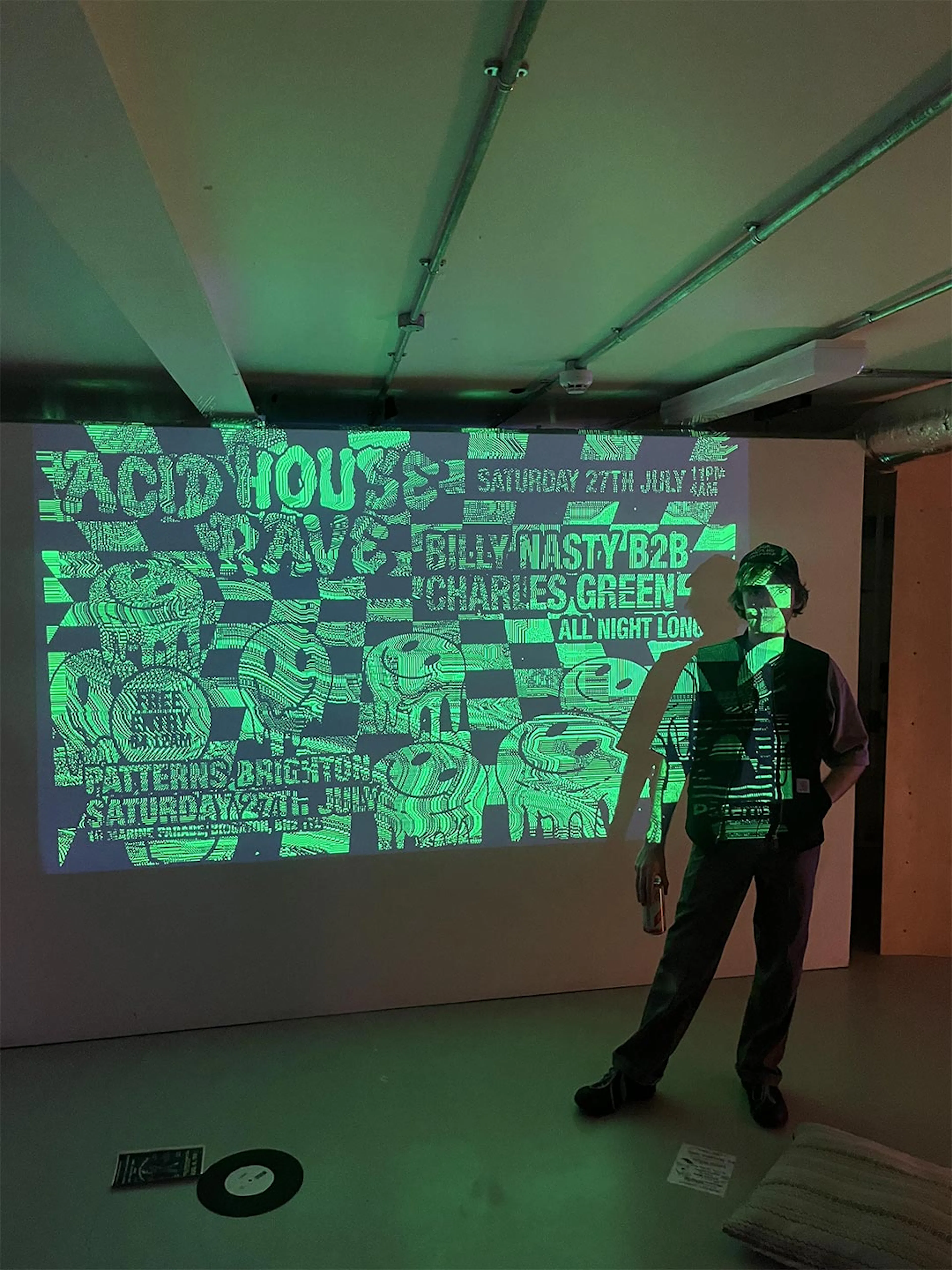 Felix Colbert standing in front of his artwork projected onto a wall at the event. 
