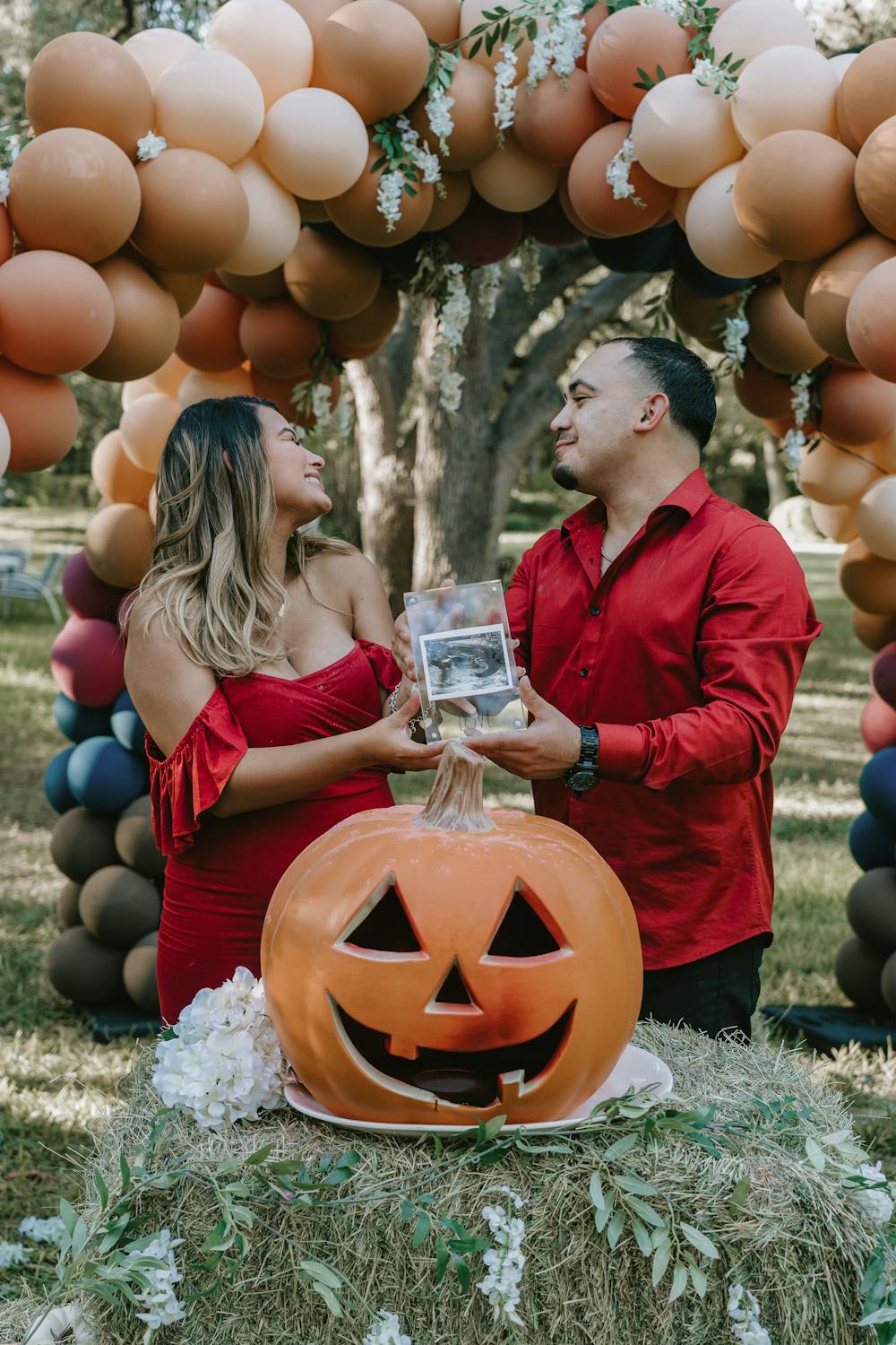 Couple celebrating Halloween in front of an balloon arch in outdoor pic
