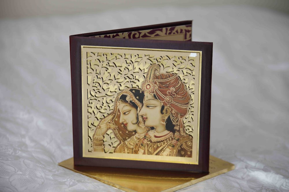 a golden Mughal king and queen design wedding card