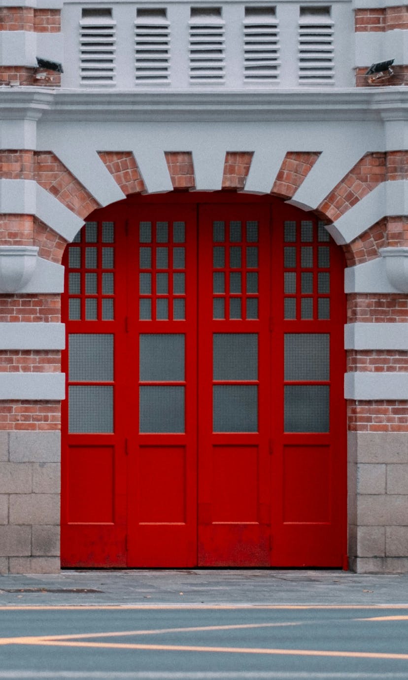 A brick firehouse with four red garage doors