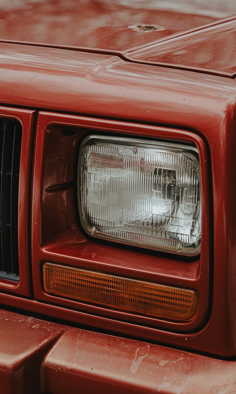 A close-up of the right front headlight of a Jeep Cherokee