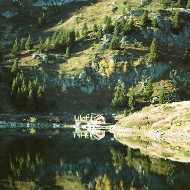 A cabin nestled on a lake in the mountains
