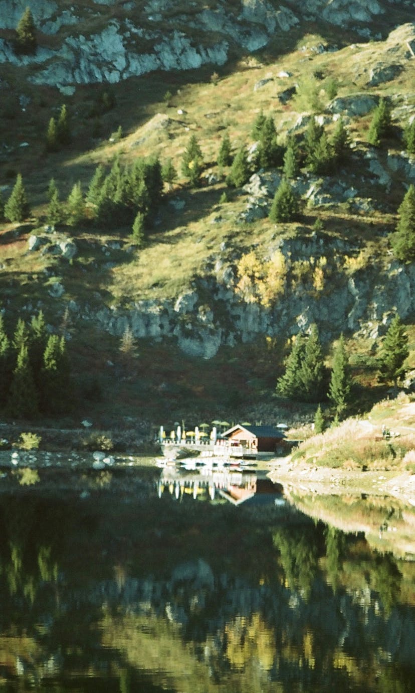A cabin nestled on a lake in the mountains