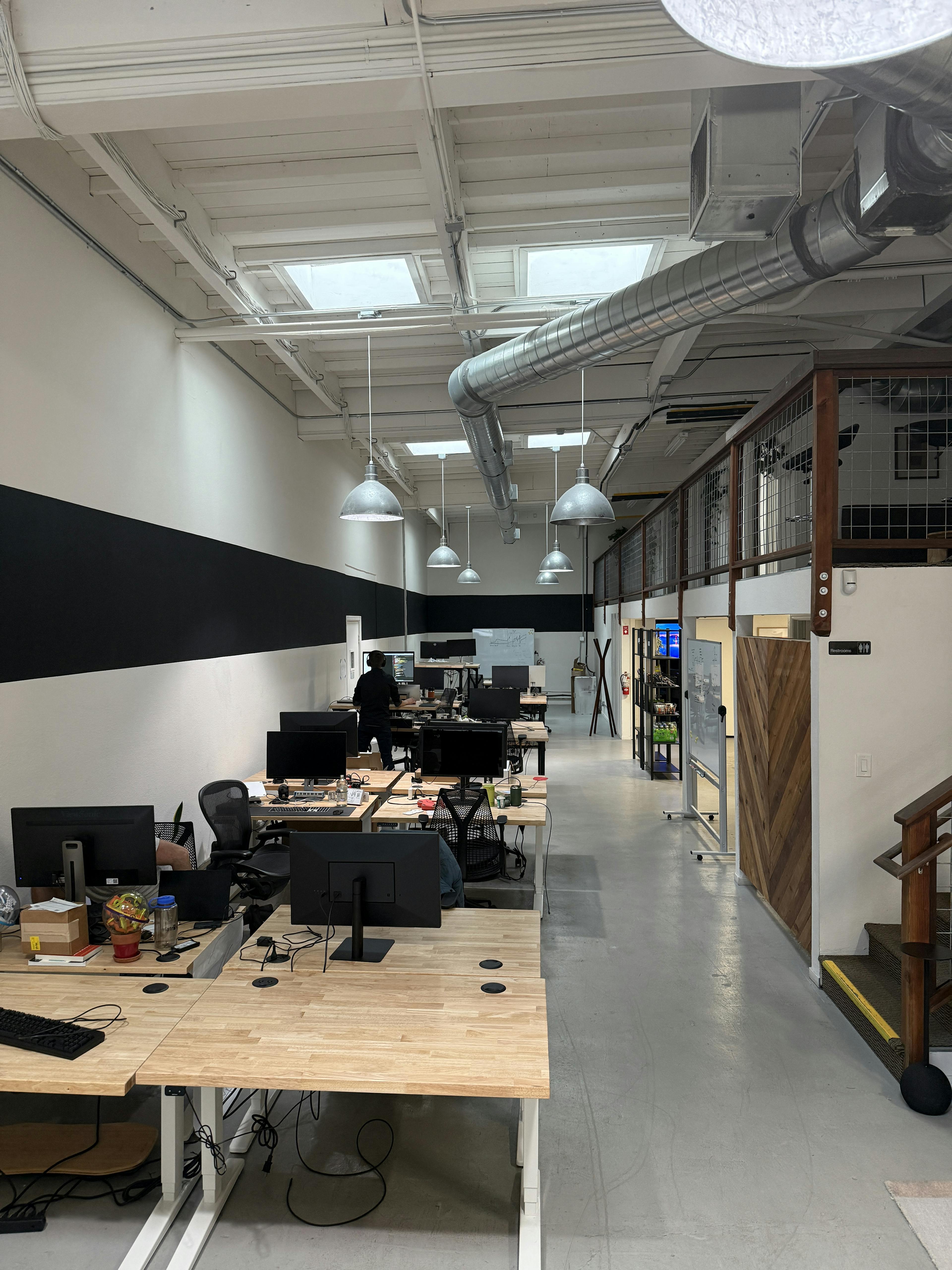 An image of a modern startup office, with desks and a balcony area.