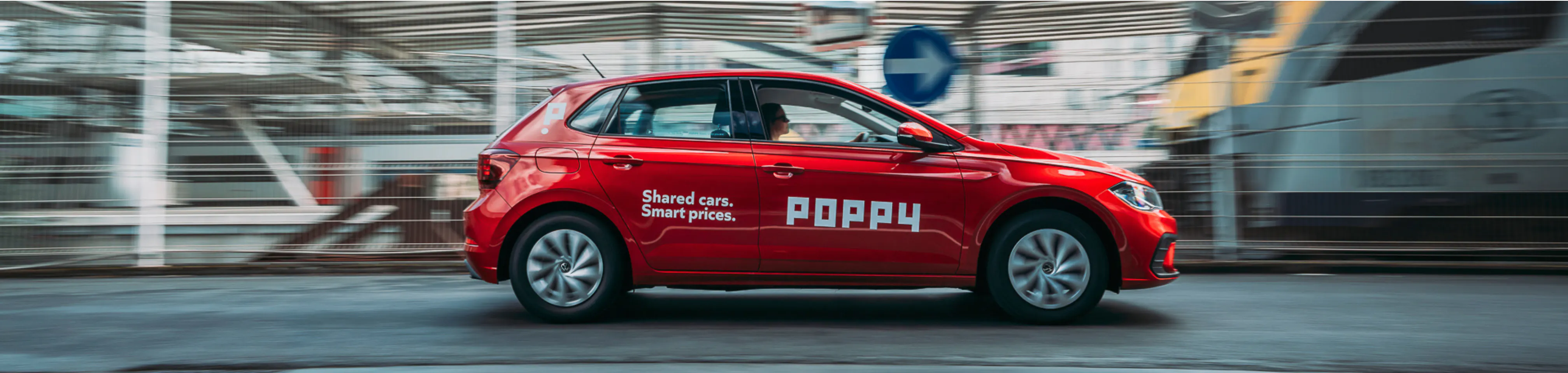 A red Poppy vehicle driving on the road