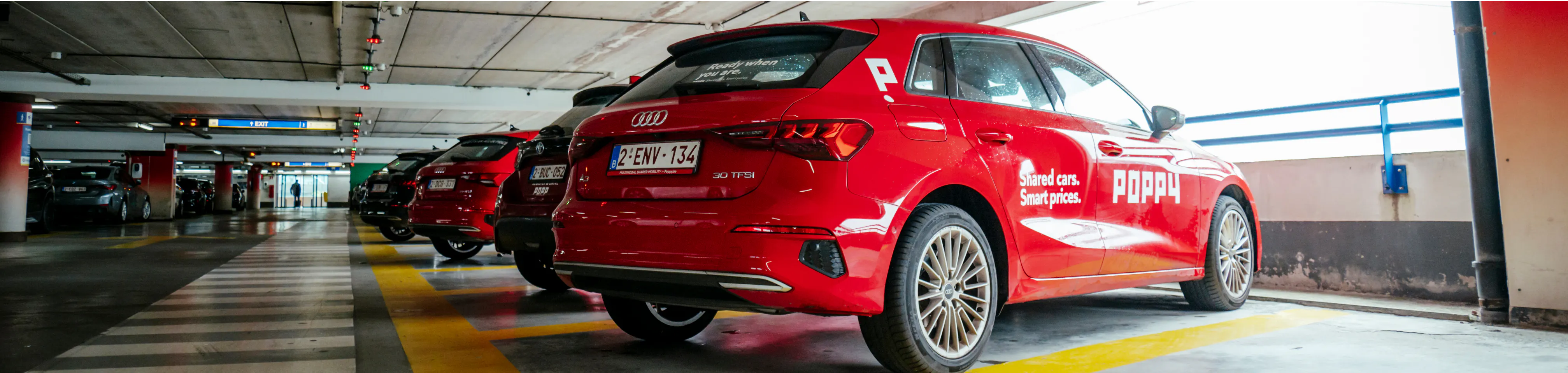 Red Poppy vehicles standing on the designated parking spots for car sharing at the airport parking in Brussels Airport.
