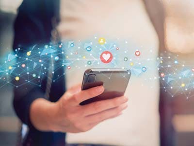 Mão segurando celular com TIM Controle redes sociais.