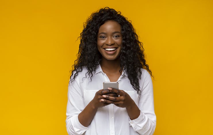 Mulher sorrindo com celular na mão