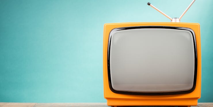 foto de uma tv amarela com antena no fundo azul