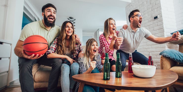 grupo de amigos comemora enquanto assiste tv